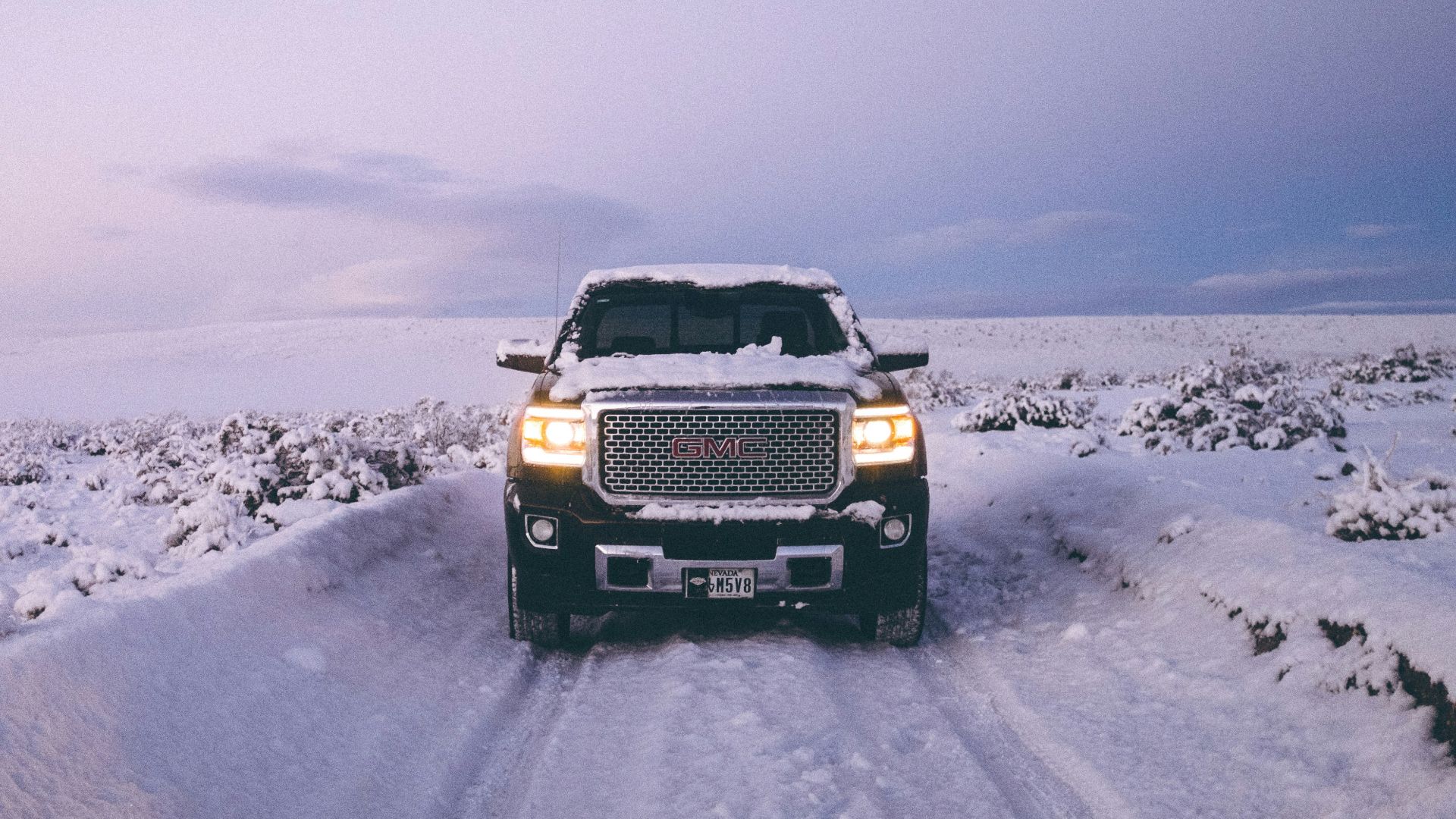 black GMC Sierra Denali on snow covered road
