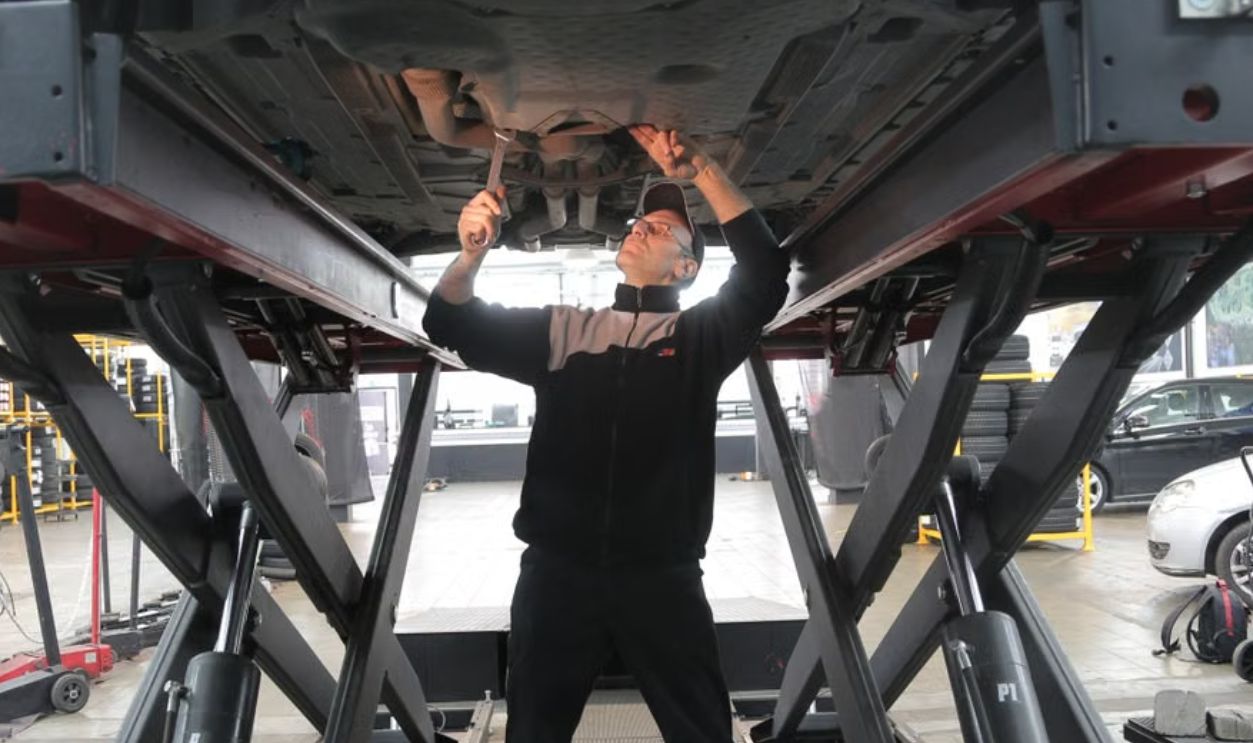 Mechanic inspecting and repairing a vehicle in a professional auto garage