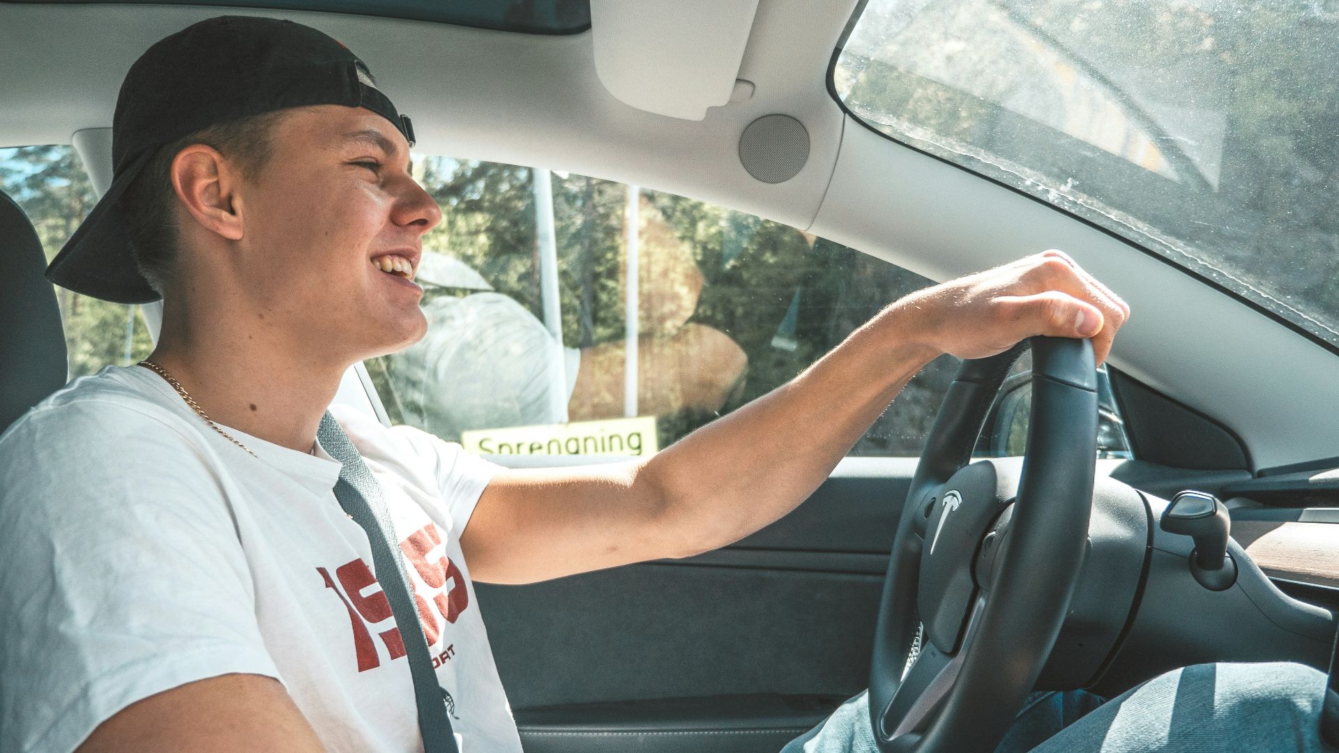 man in white crew neck t-shirt driving car