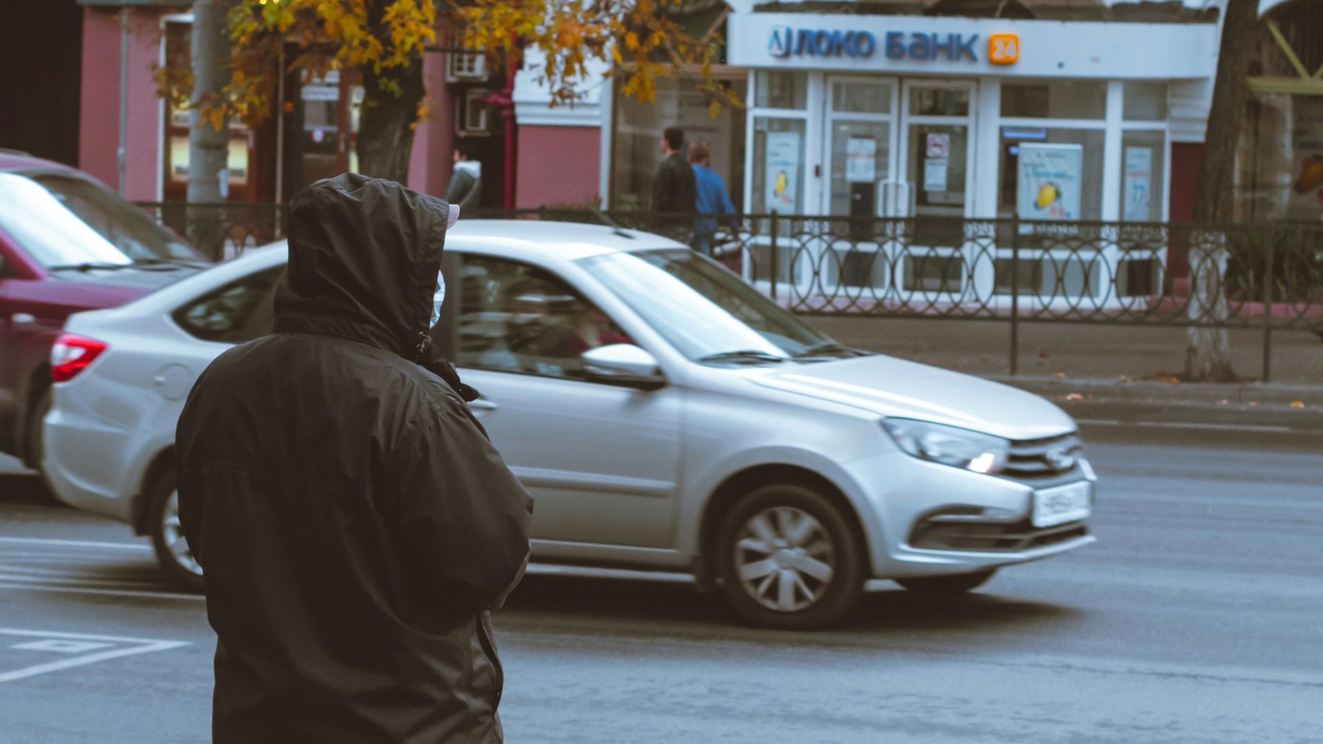 a man standing on the side of a road next to a traffic light