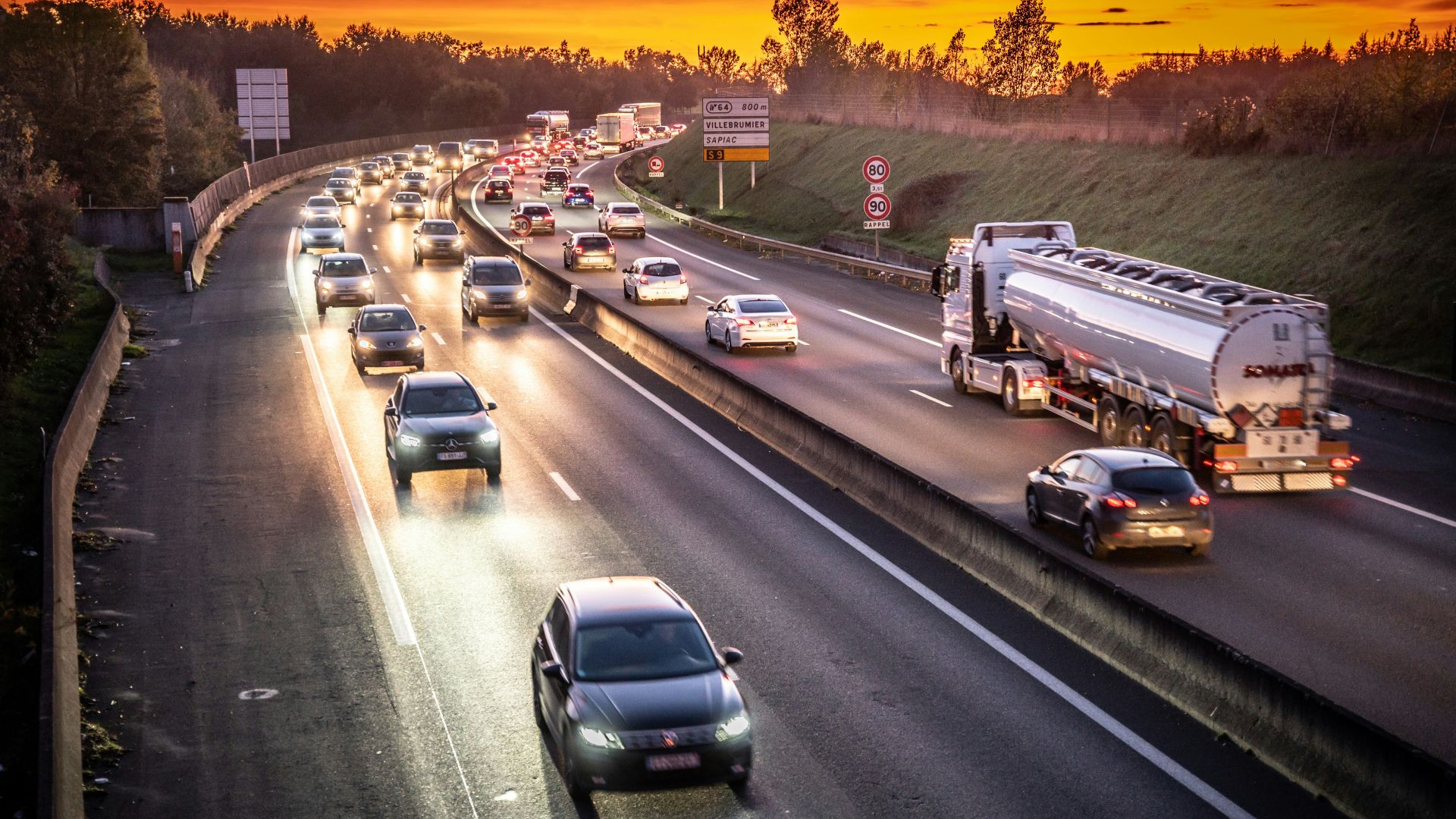 A highway filled with lots of traffic at sunset