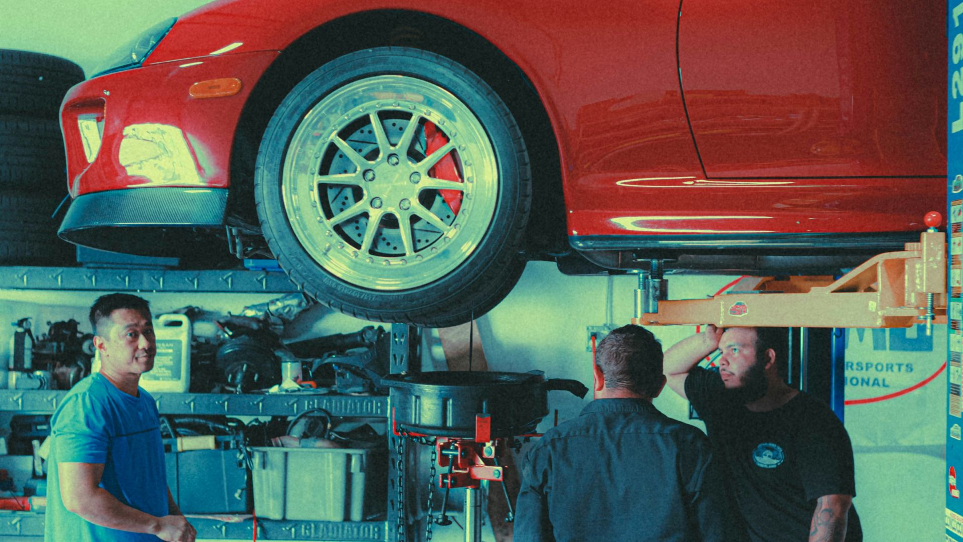 a group of men working on a car in a garage