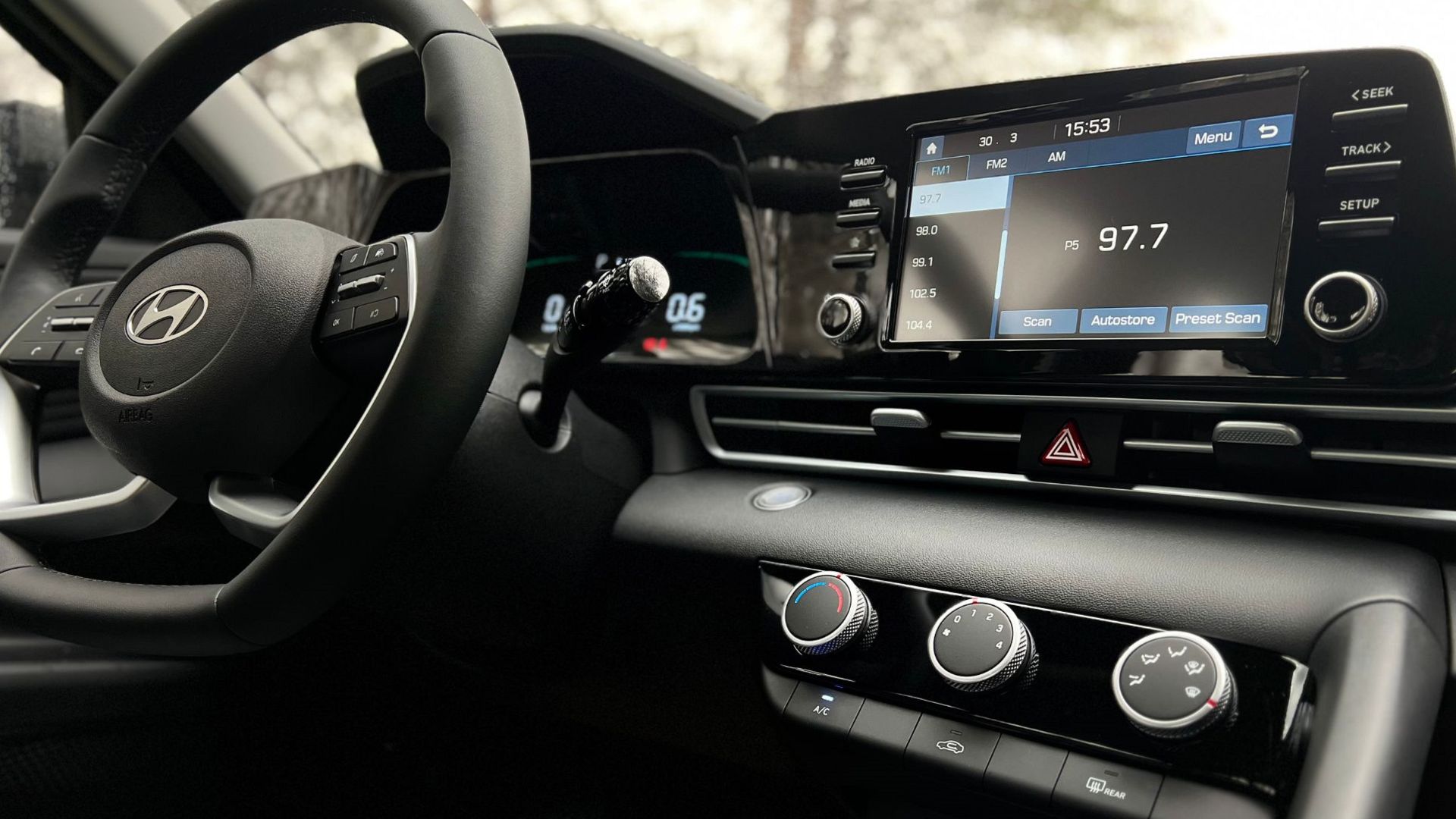 Interior view of a modern car dashboard featuring a touchscreen infotainment system and steering wheel.