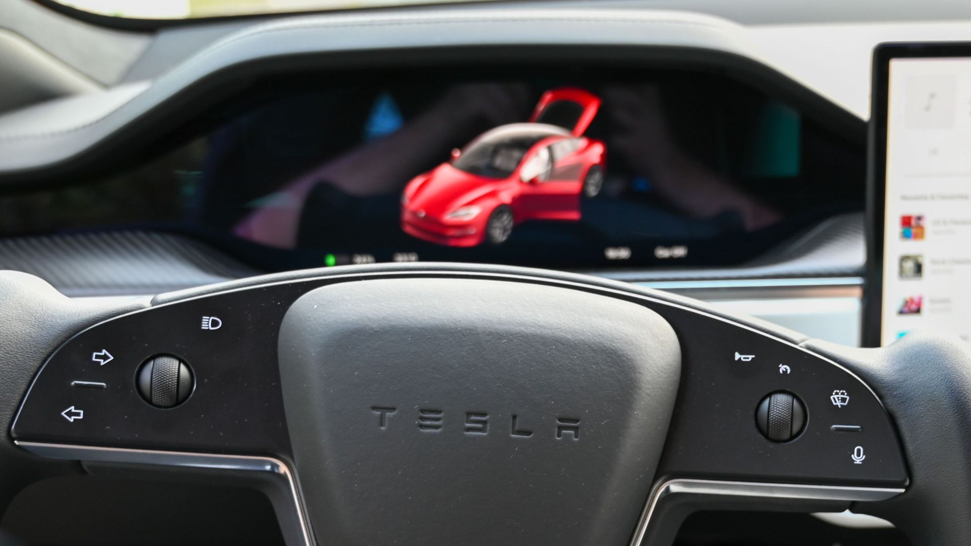 Close-up of a modern car's dashboard featuring a steering wheel and digital screen display.