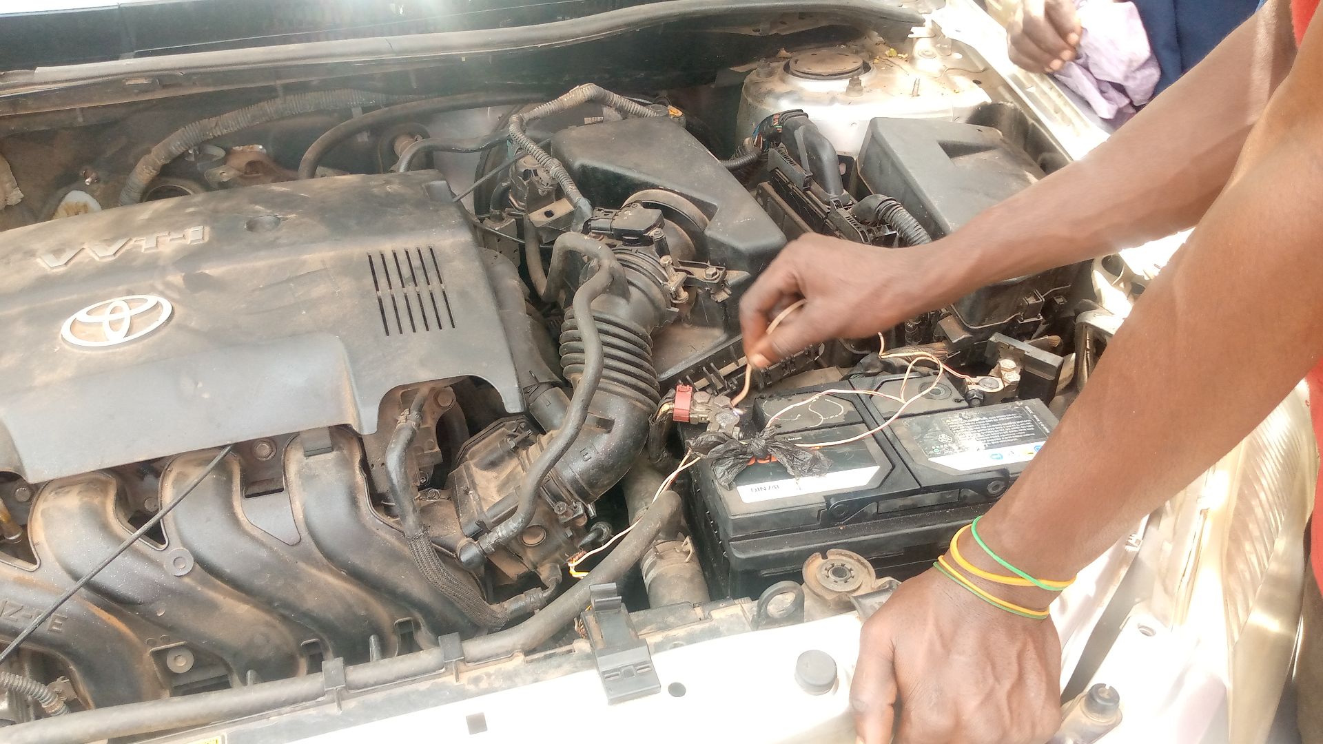 Mechanic checking the car battery for any faults