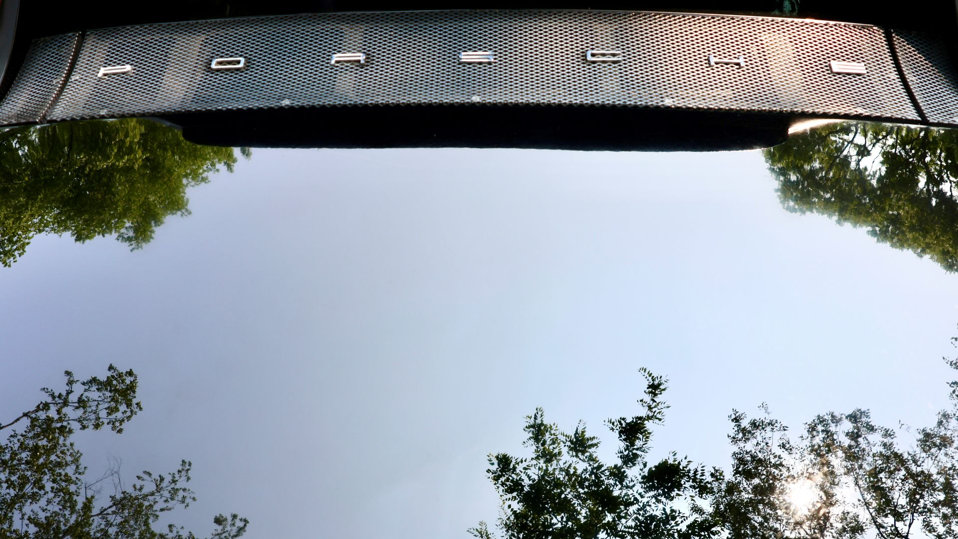 a rear view mirror of a car with trees in the background