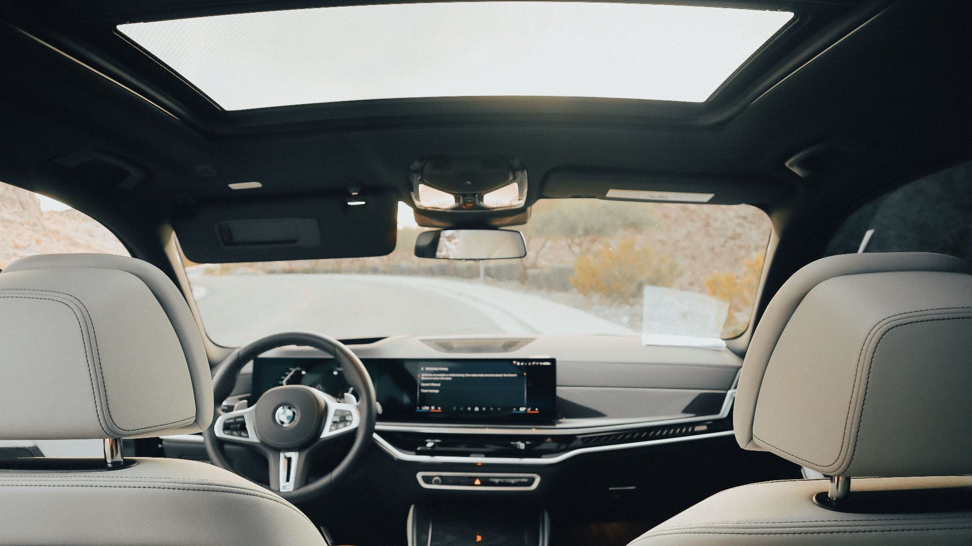 Explore a luxurious car interior featuring a panoramic sunroof and modern dashboard.