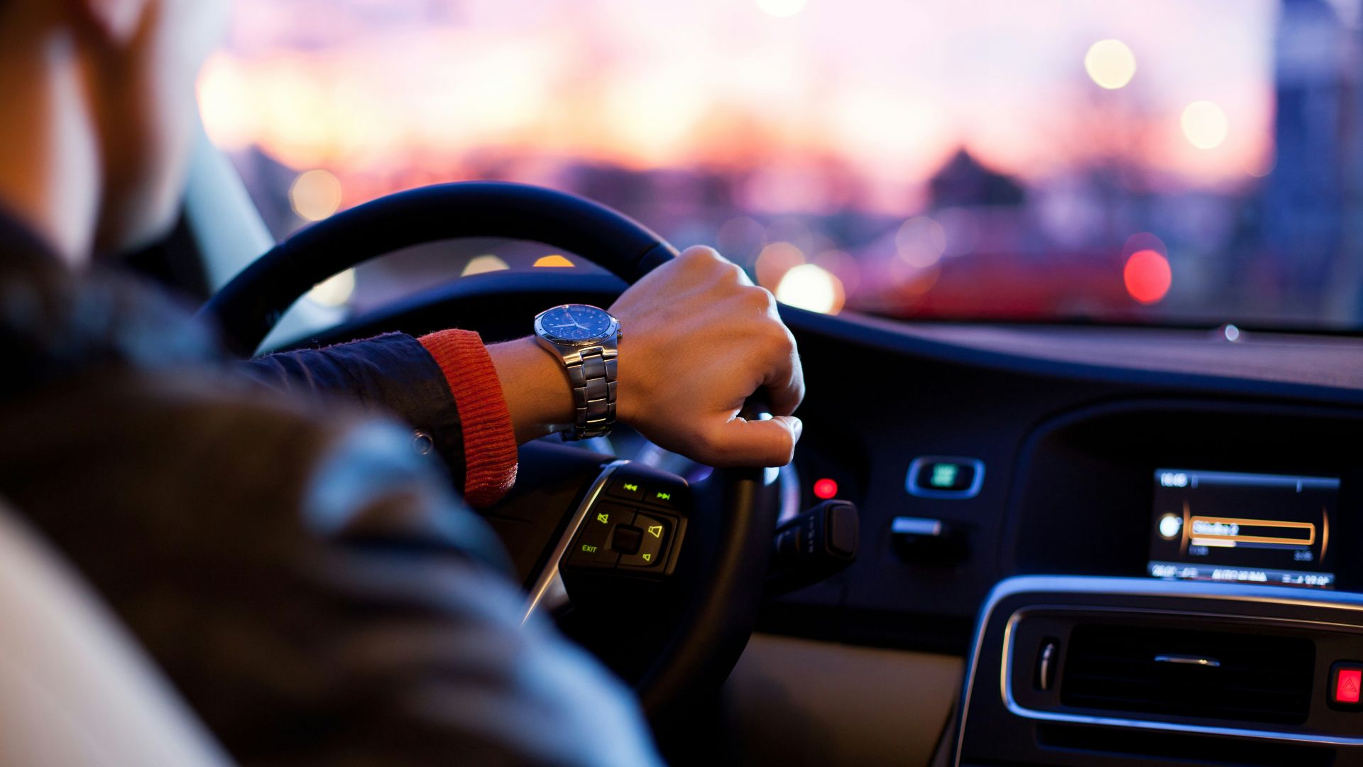 man driving a car wearing wrist watch