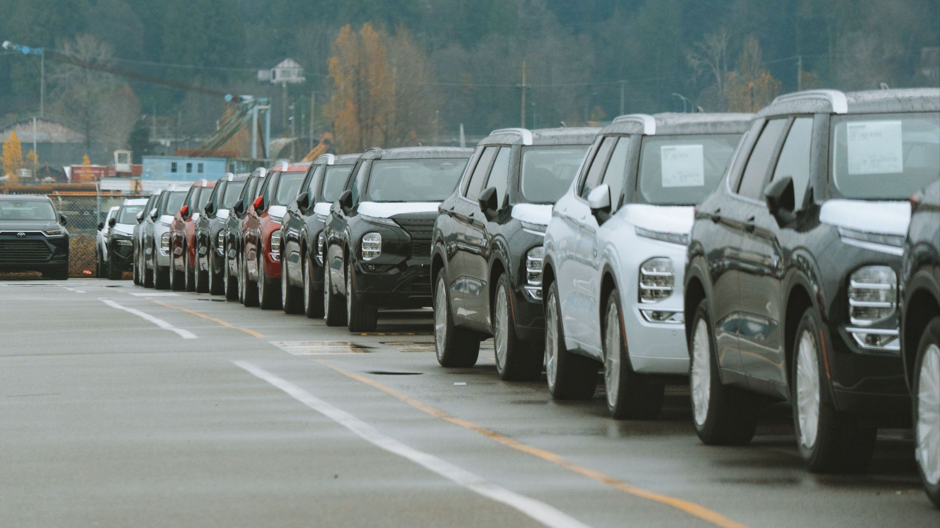 A line of new SUVs parked in an outdoor dealership lot, ready for sale.