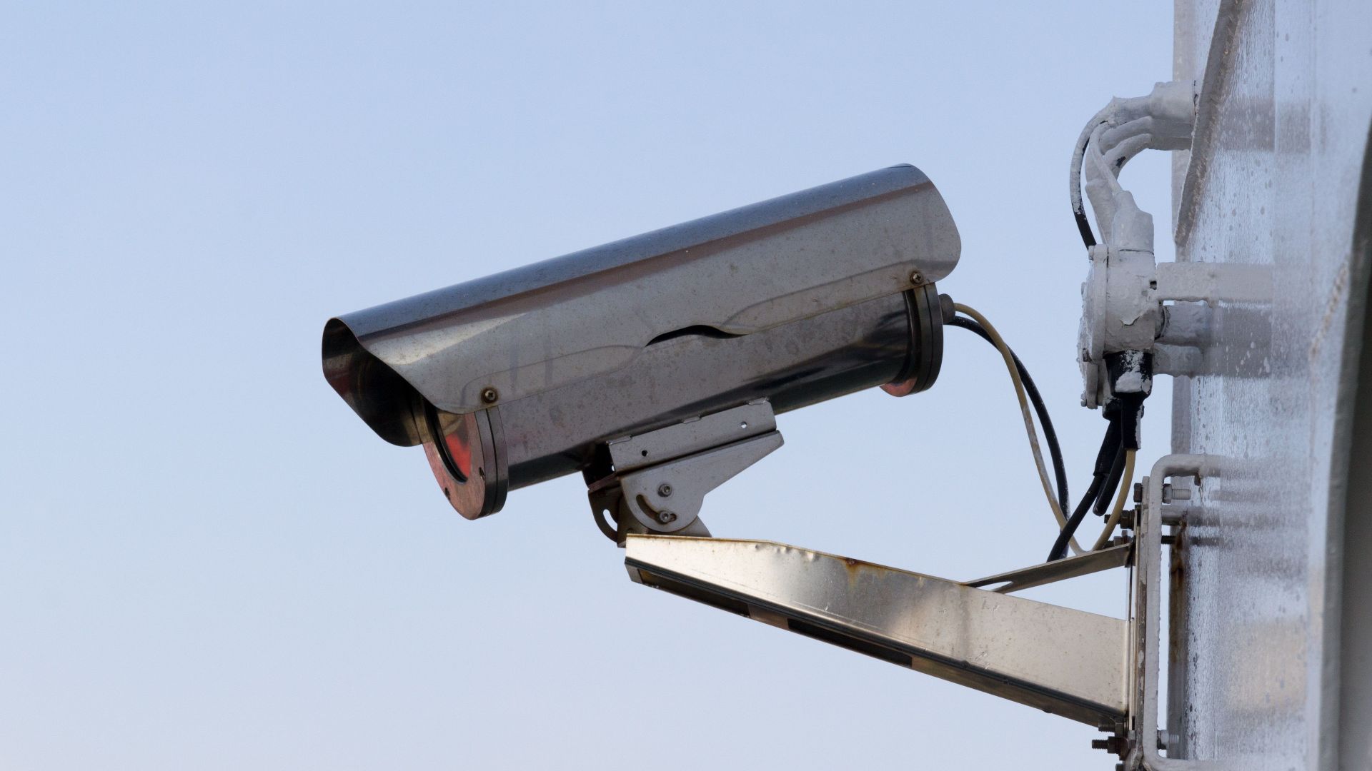 Close-up of an outdoor CCTV camera installed on a wall for security purposes.
