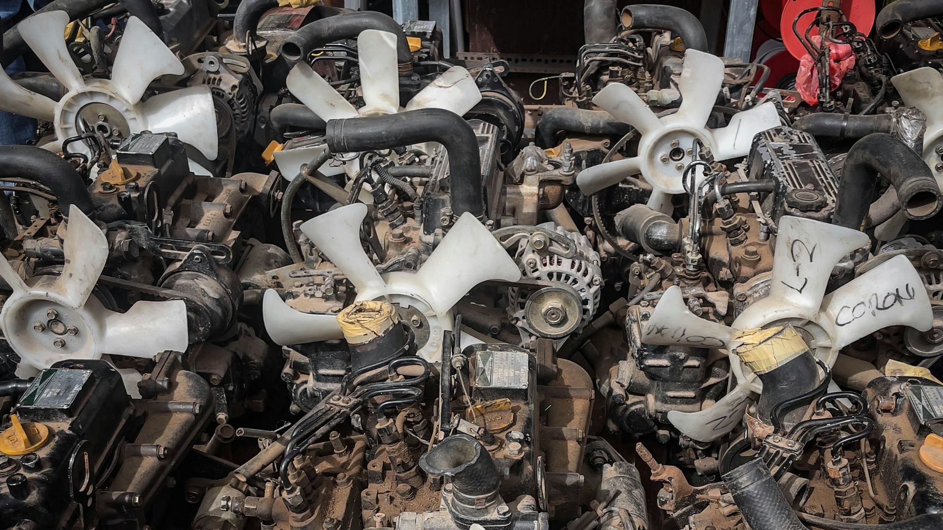 Rows of car engines with fans and hoses