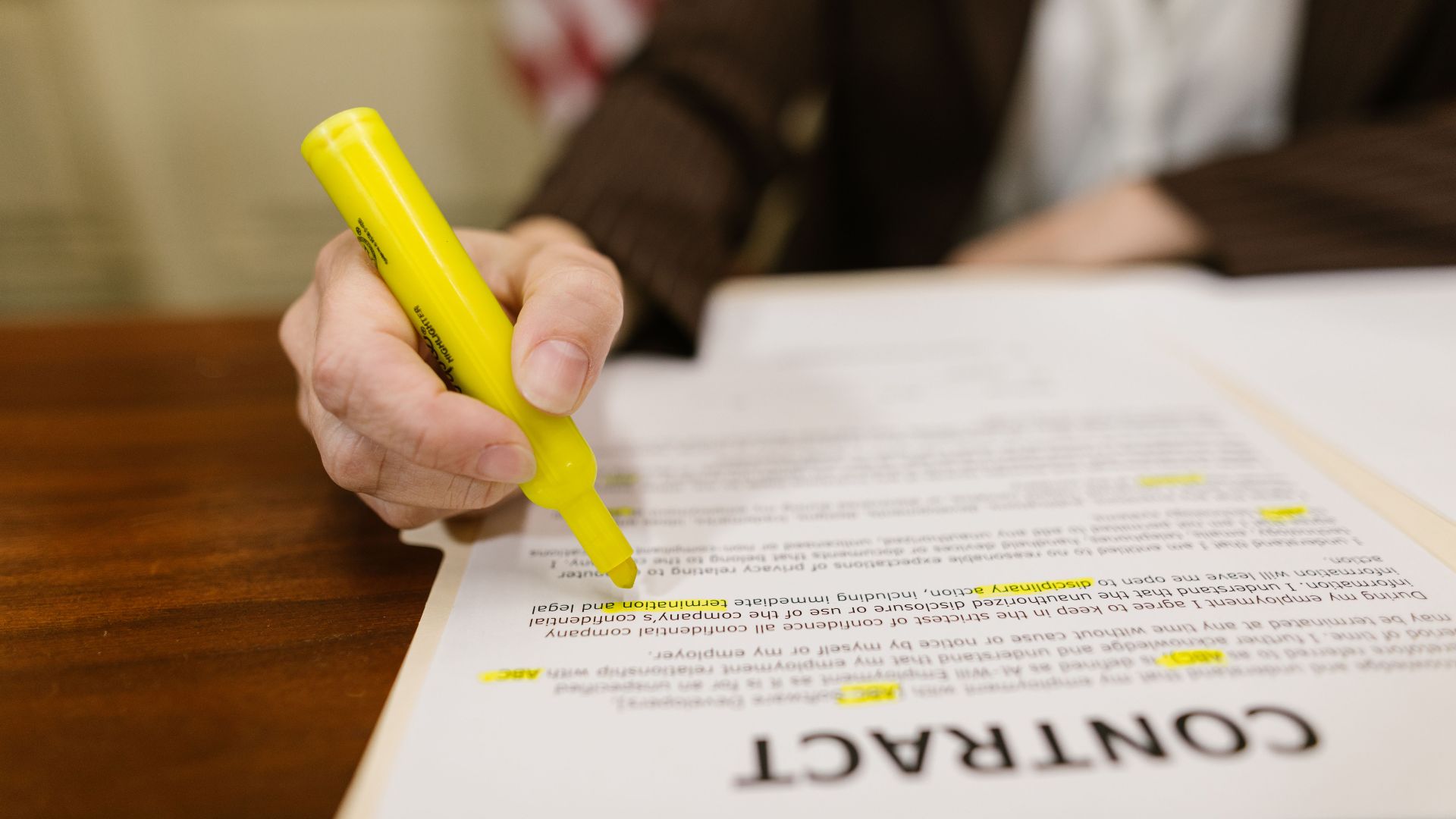 A close-up of a hand highlighting a contract, emphasizing important legal terms.
