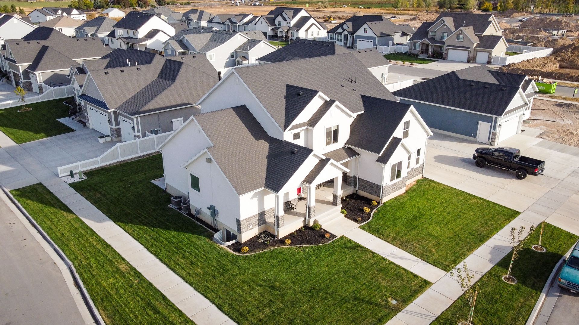 Aerial shot of a residential area in Spanish Fork, Utah showcasing modern homes and manicured lawns.