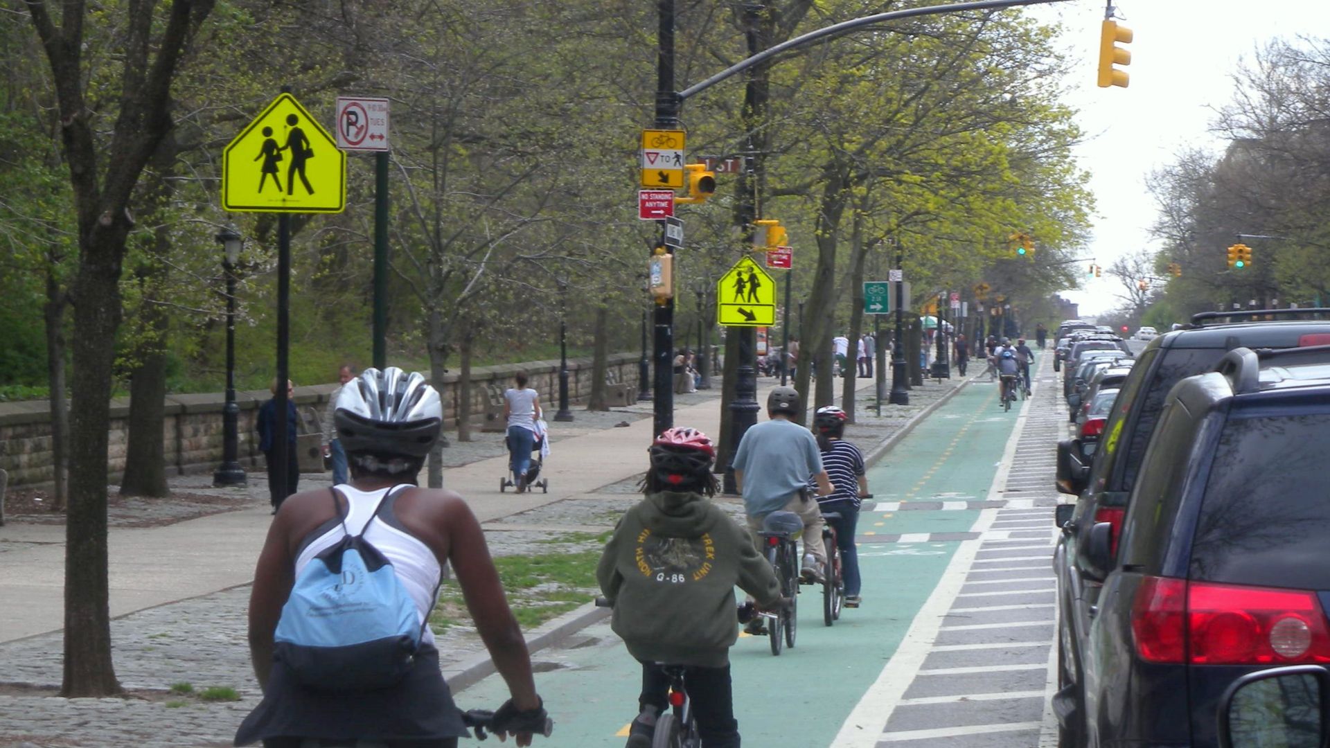 Looking south at Prospect Park West protected bike lane on a cloudy midday.