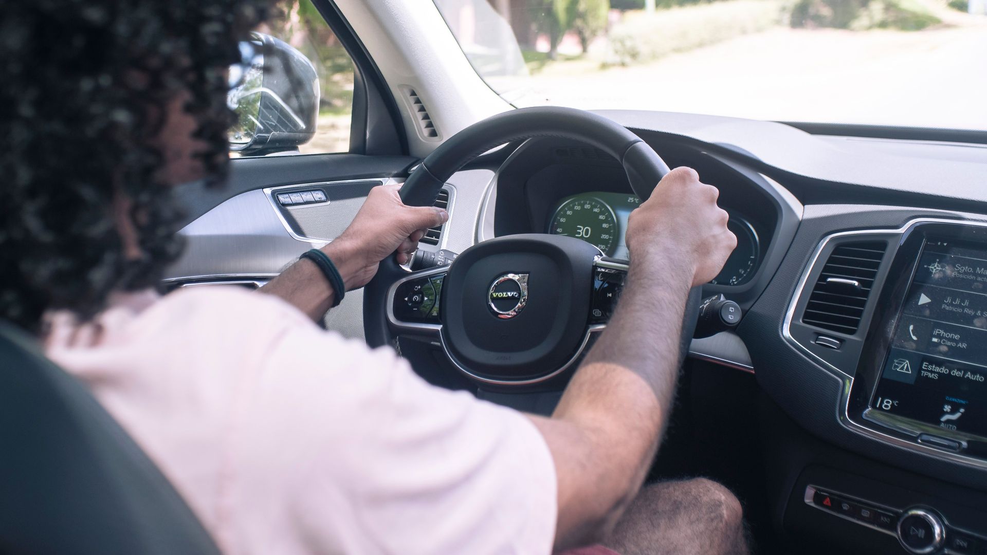 A man driving a car with attention focused on the road ahead, showcasing modern vehicle technology.