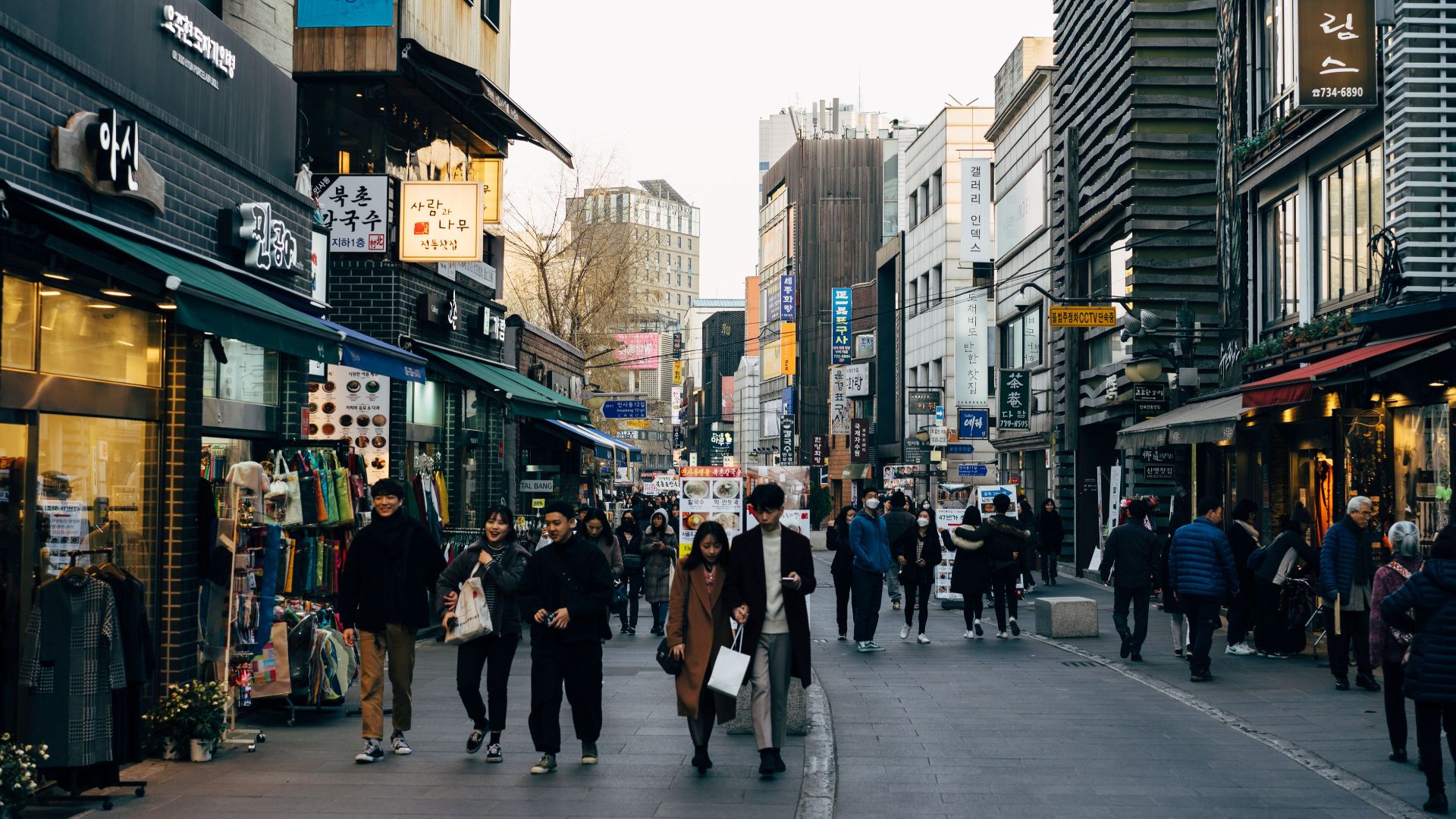 Lively shopping street in Seoul with people walking, shops, and vibrant city life.