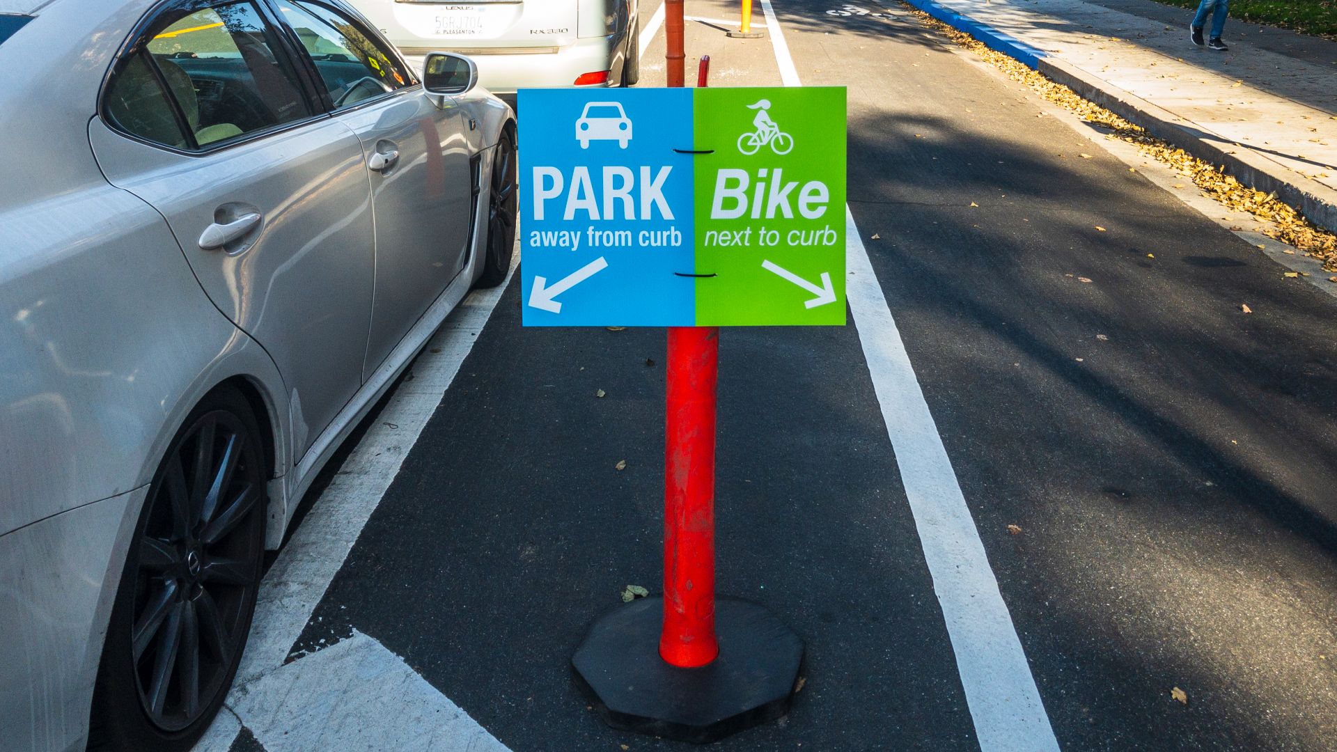 A new curbside bicycle lane at San Jose State University (SJSU) on San Fernando Street, where parking is offset away from the curb.  Located at 7th Street and San Fernando Street in San Jose, CA in the San Francisco Bay Area. Complaints of driver confusio