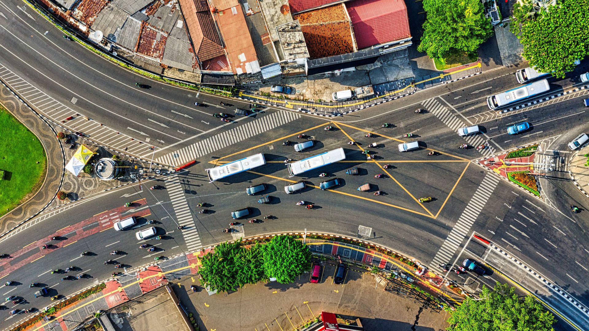 Dynamic aerial view of a busy urban intersection in Jakarta, showcasing city traffic and infrastructure.