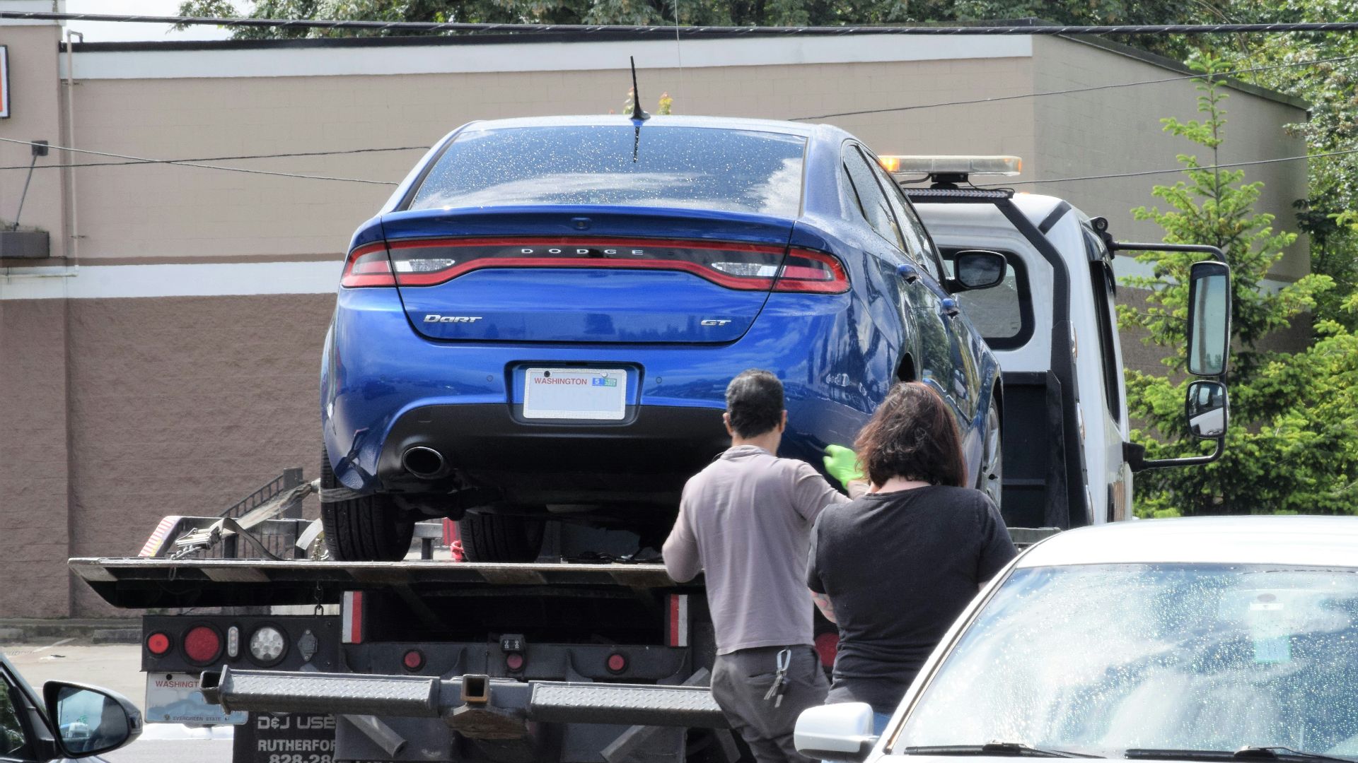 a blue car being loaded onto a flatbed truck