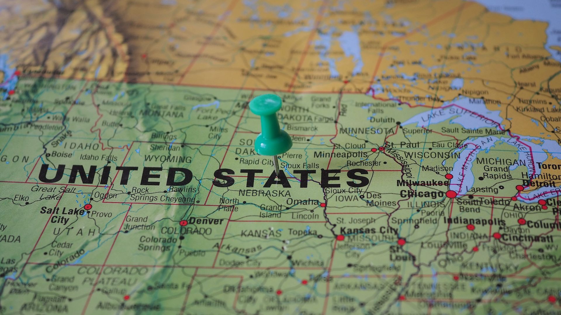High-angle view of a map featuring the United States with a green pin indicating a specific location.