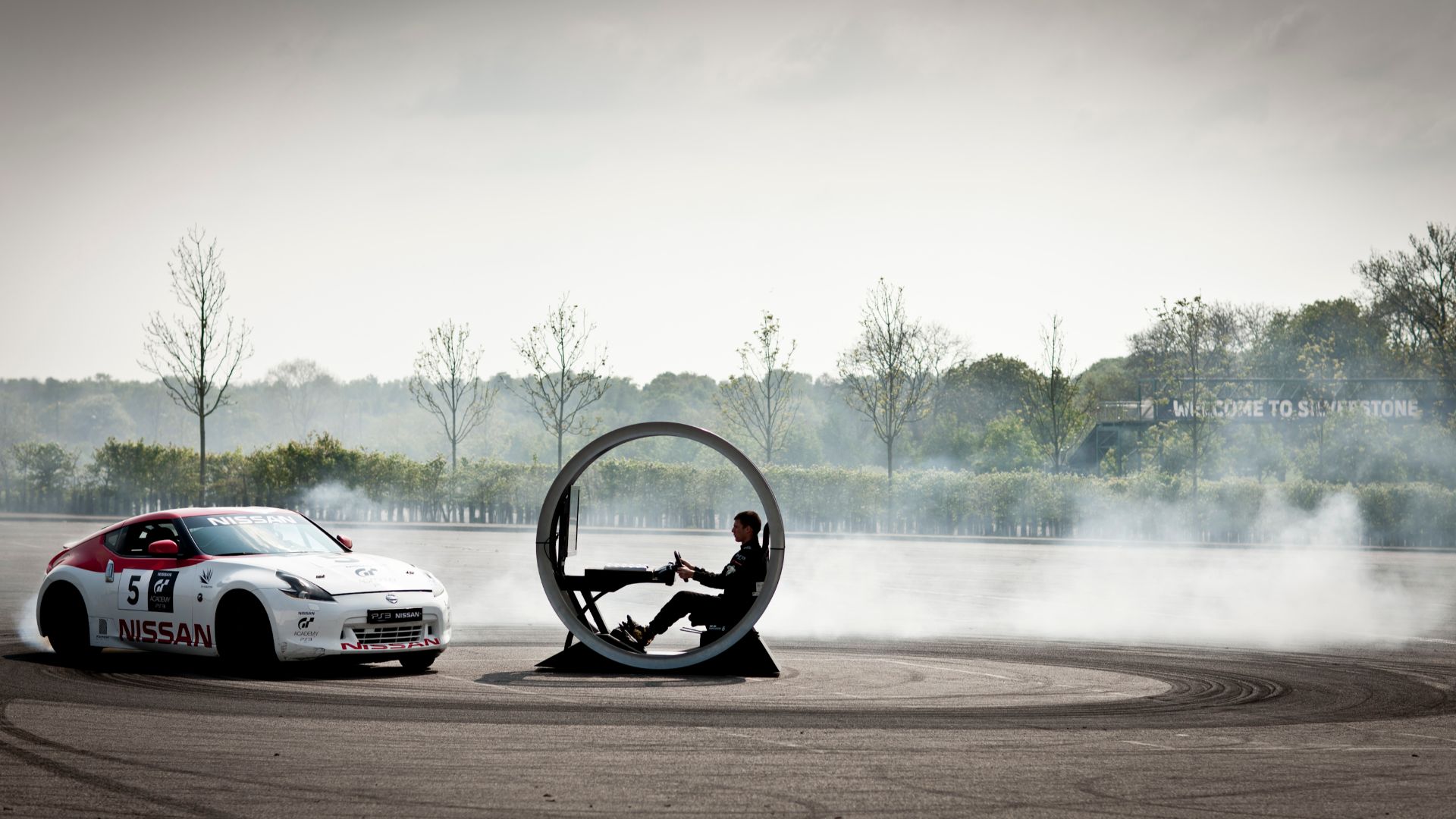 Nissan 370Z doing donuts around a Sony Playstation gaming pod
