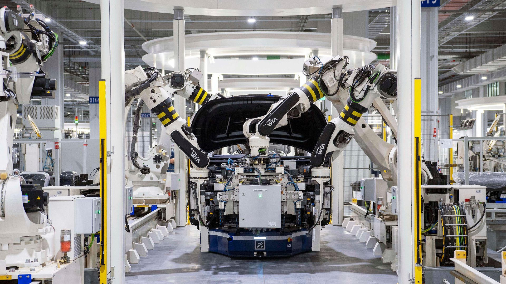 High-tech robots assembling a car in a modern factory setting, showcasing automation.