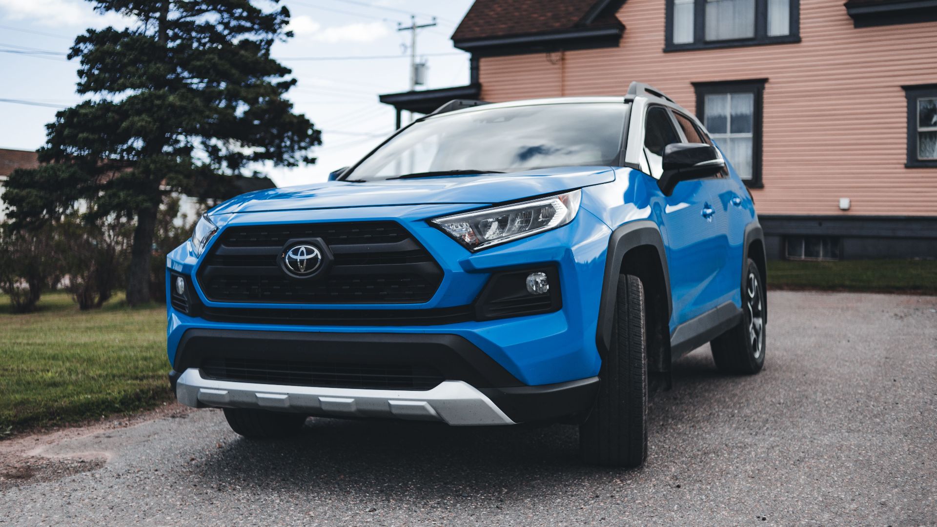 Blue Toyota SUV parked outside a house, showcasing modern automotive design in a suburban setting.