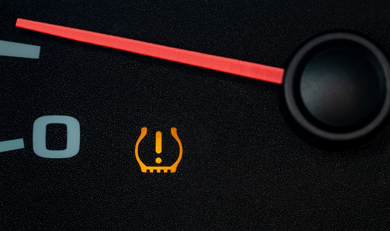 Car low tire pressure warning light. Vehicle repair, maintenance, and cold weather safety concept.
