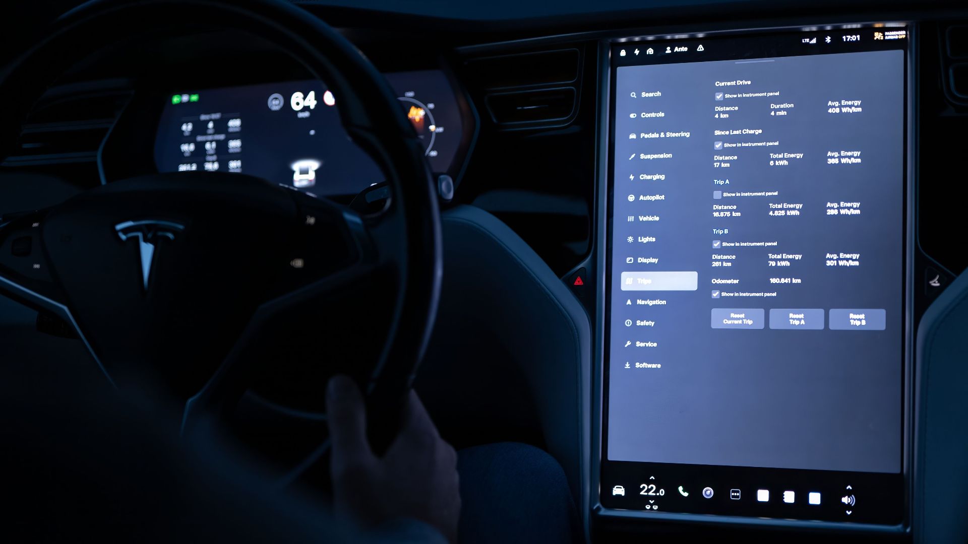 Interior view of an electric car showing advanced touchscreen and steering wheel at night.