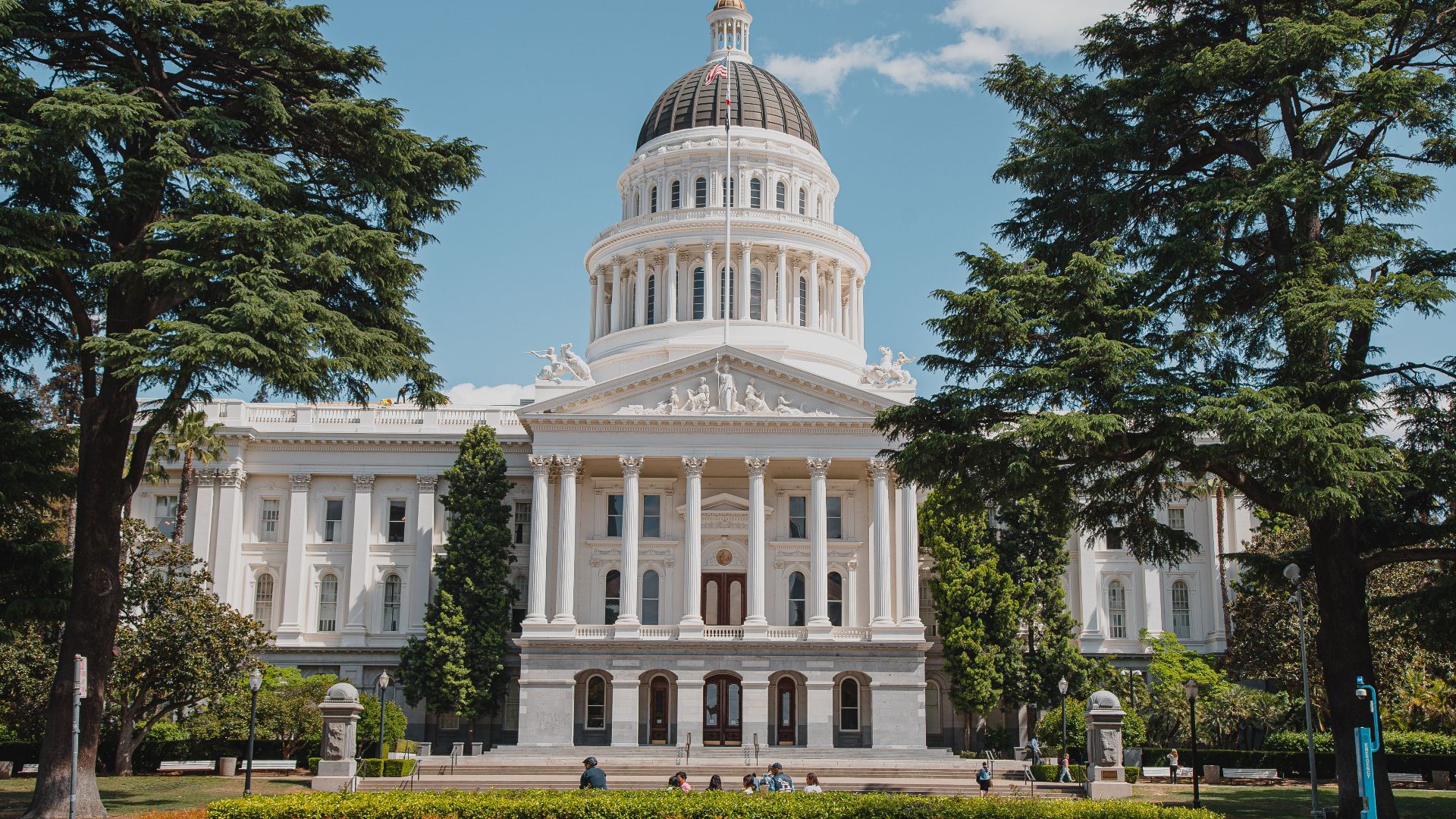 Majestic view of a historical capitol building surrounded by lush greenery.