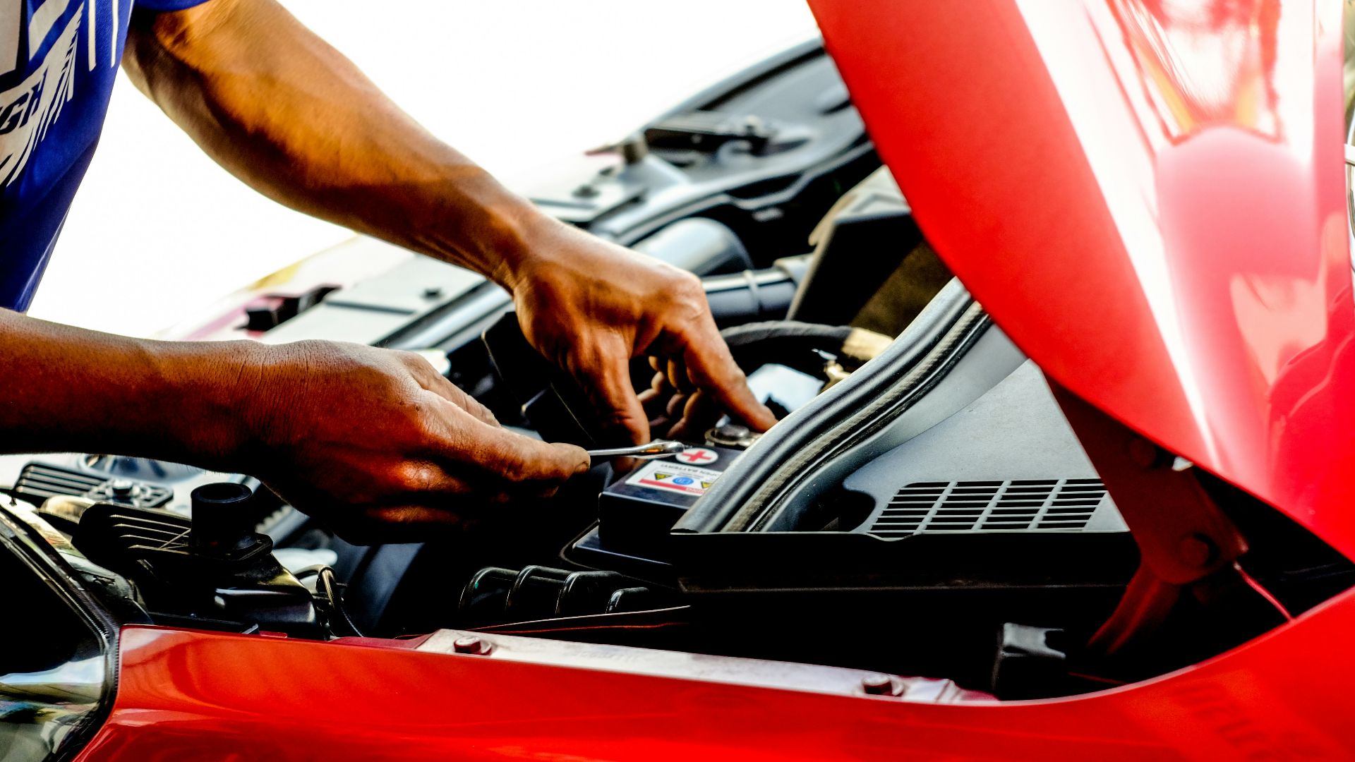 person fixing car during daytime