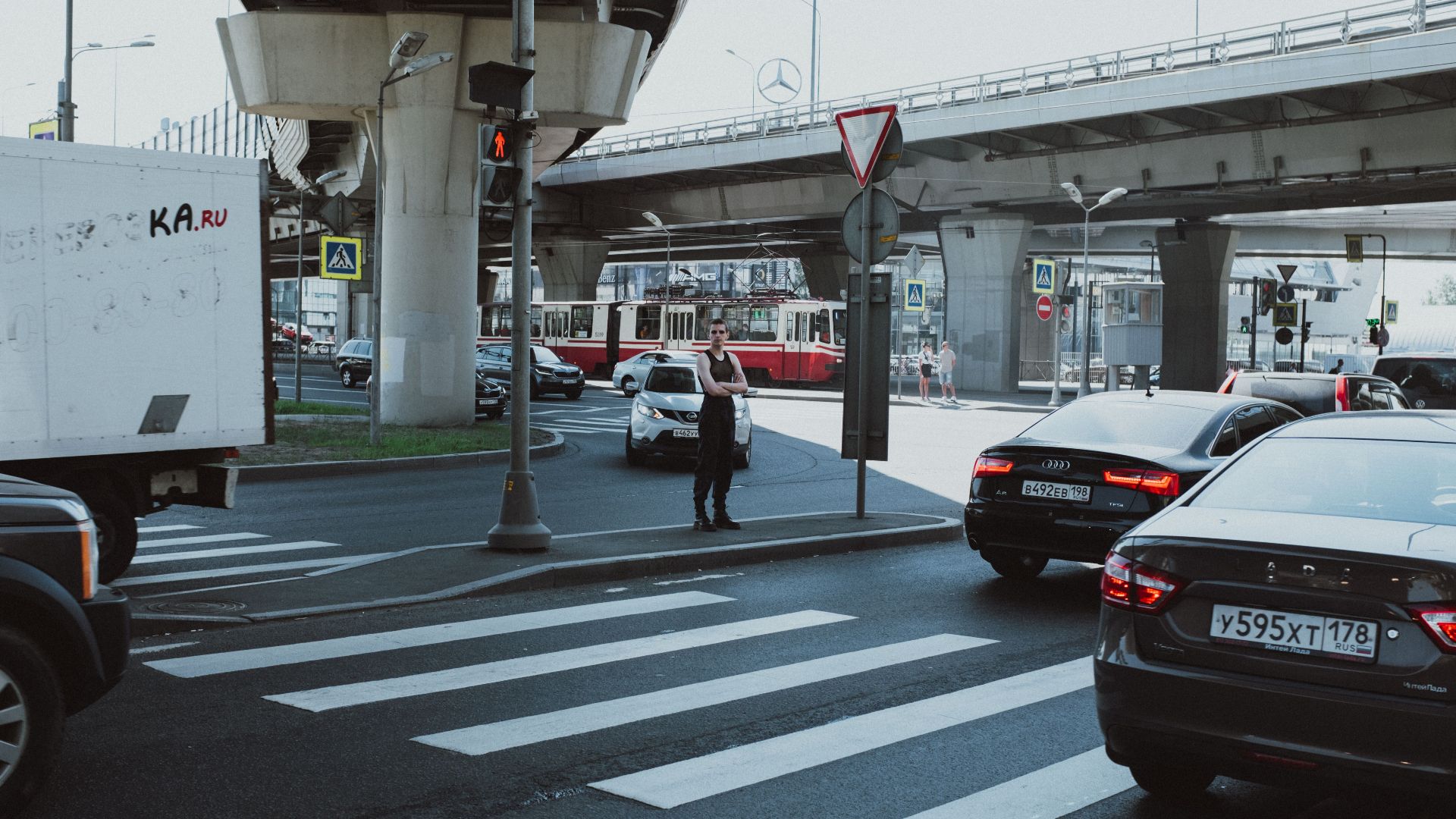 City intersection with moving vehicles and pedestrian in an urban setting.