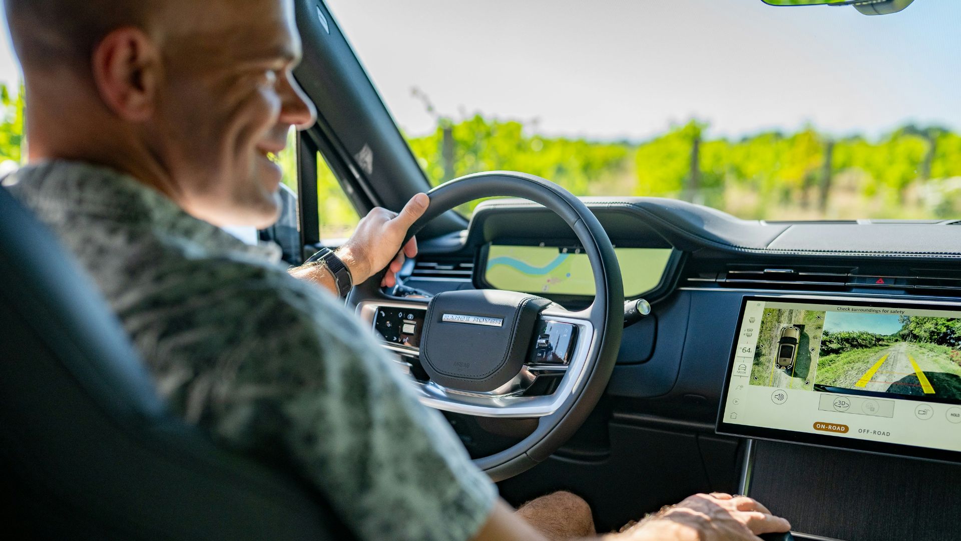 Man driving a modern car through a vineyard