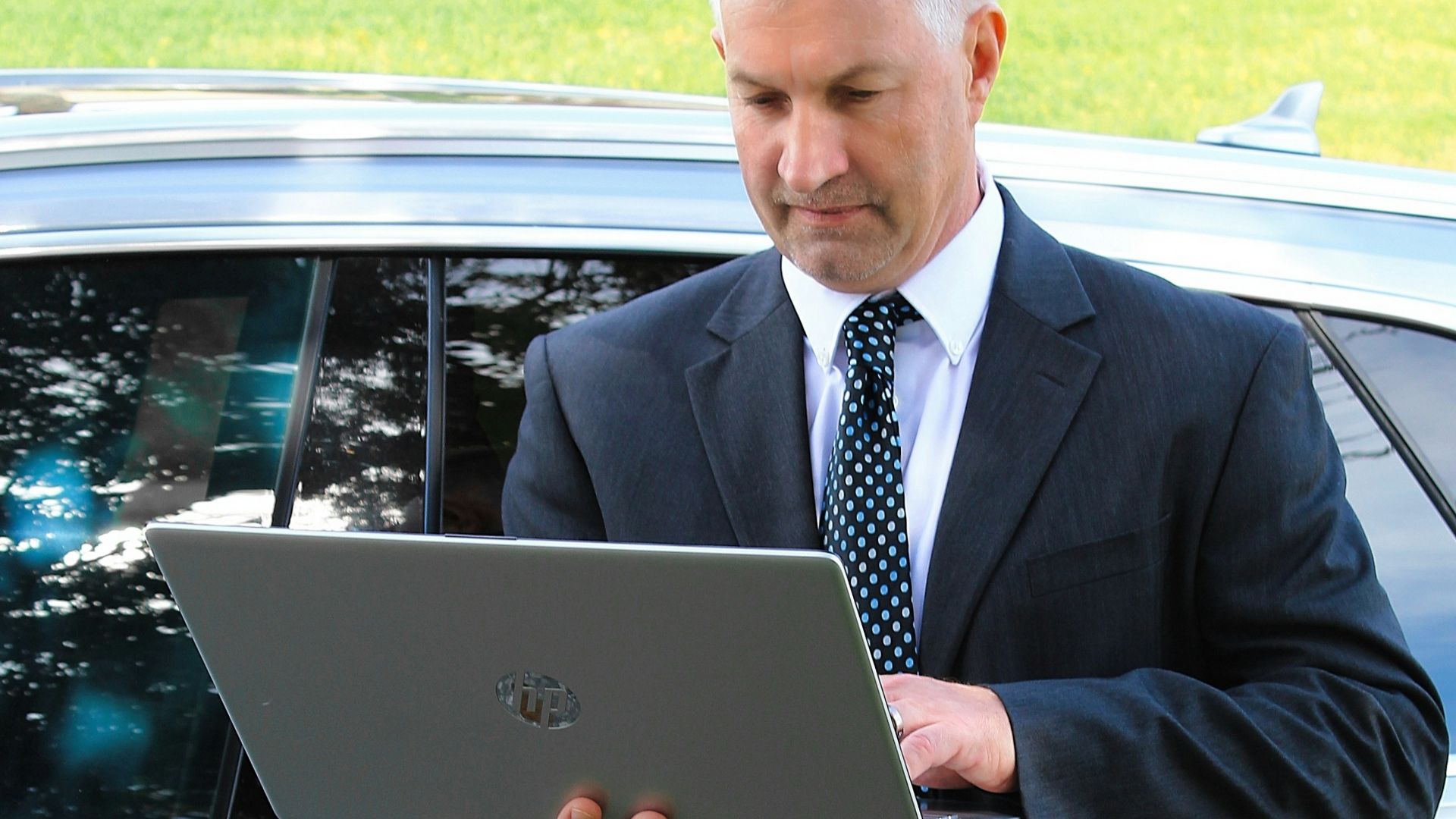 a man in a suit is looking at a laptop