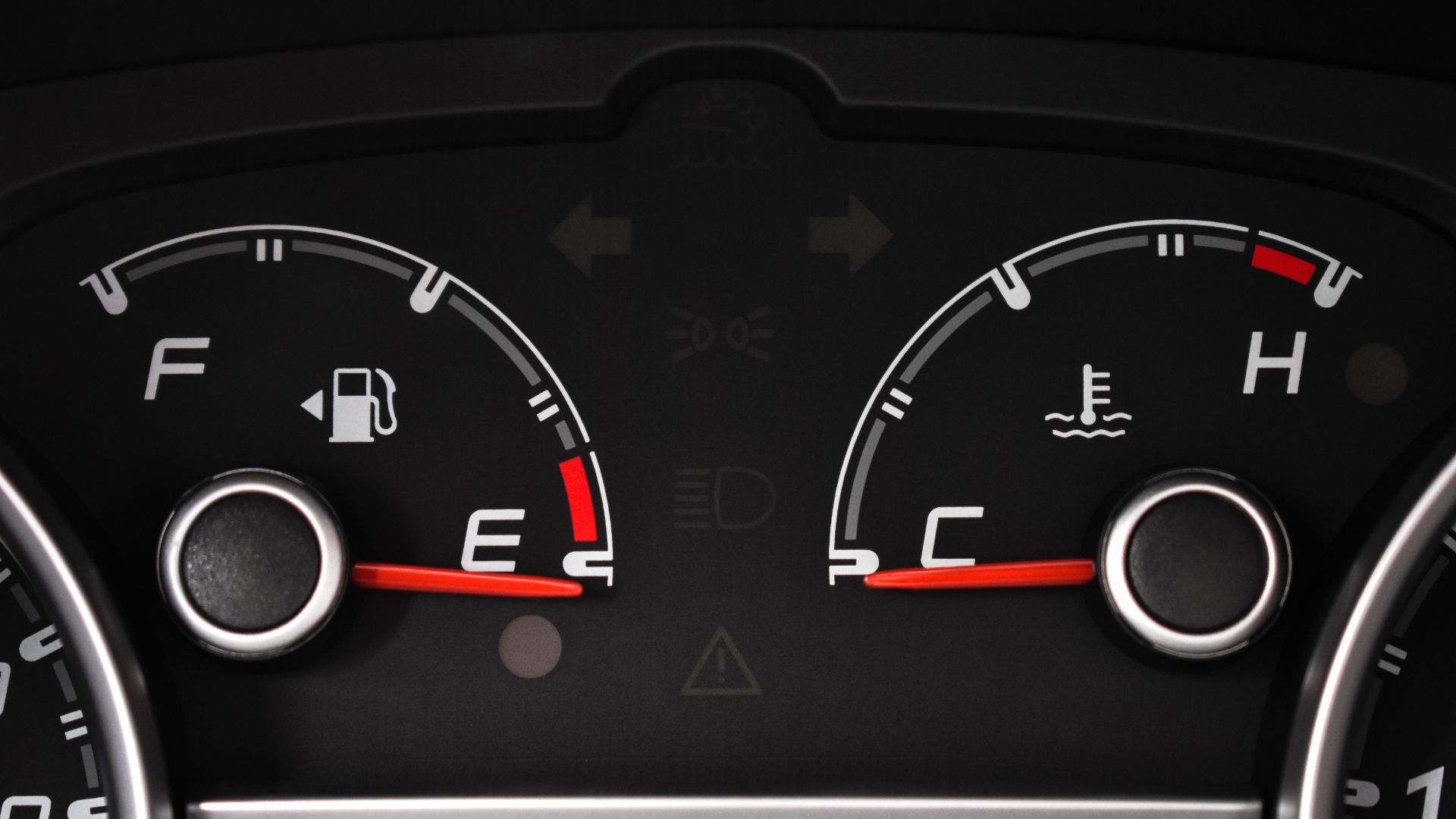 Detailed view of a car's fuel and temperature gauges on dashboard.