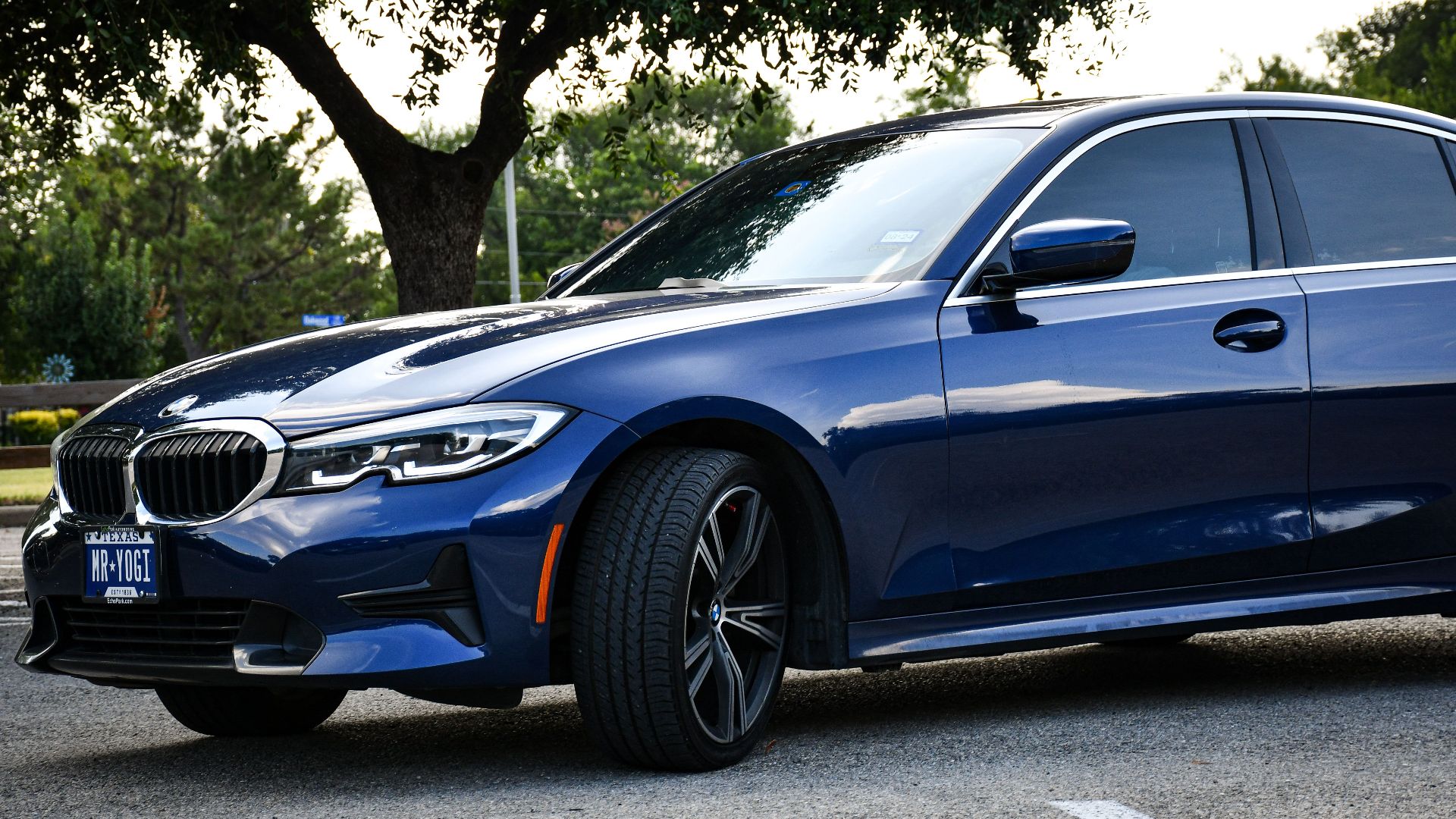 Blue sedan parked outdoors on a summer day in Arlington, Texas, showcasing luxury design and style.