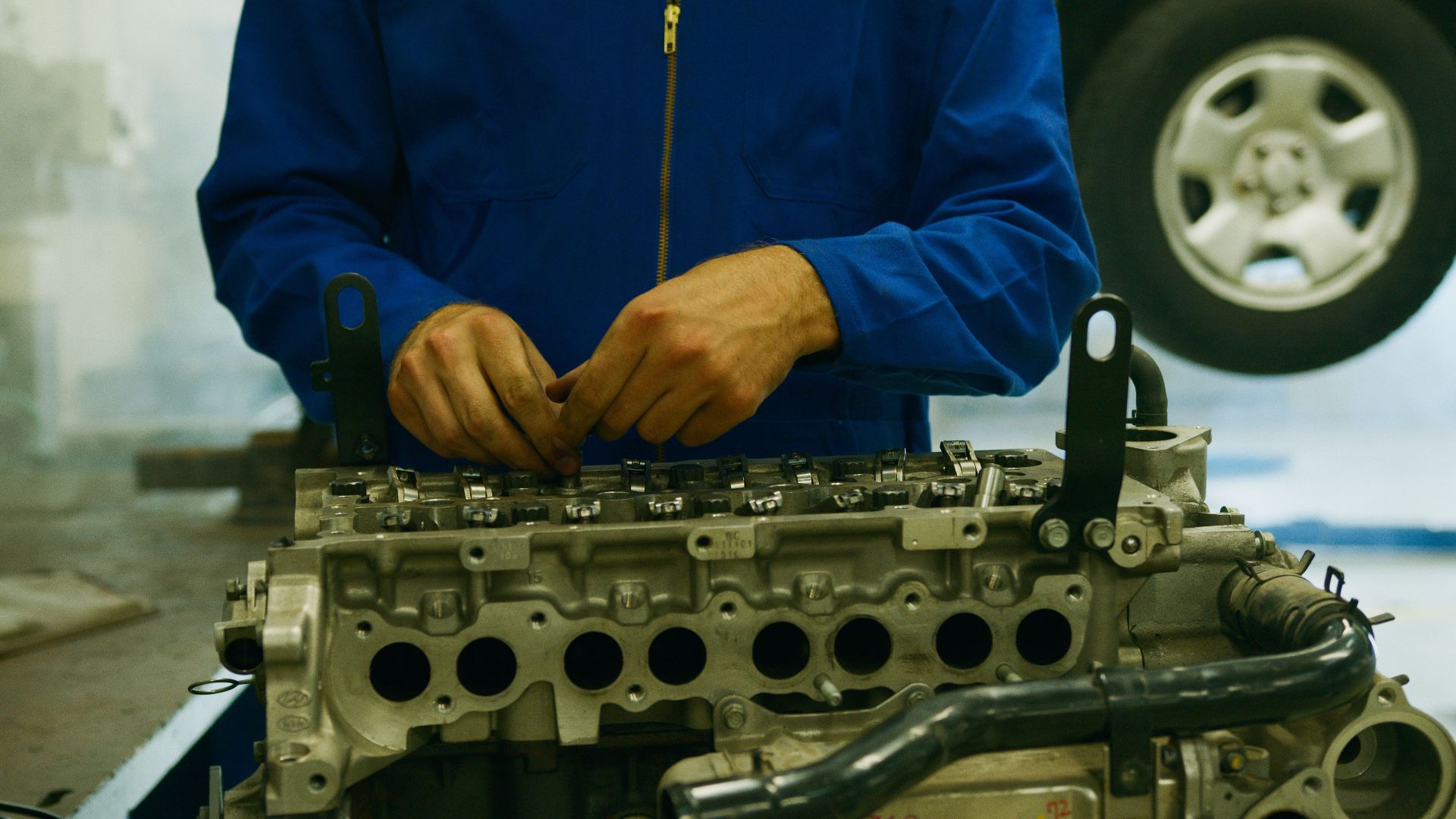 Close-up of a mechanic repairing an engine in a garage setting.