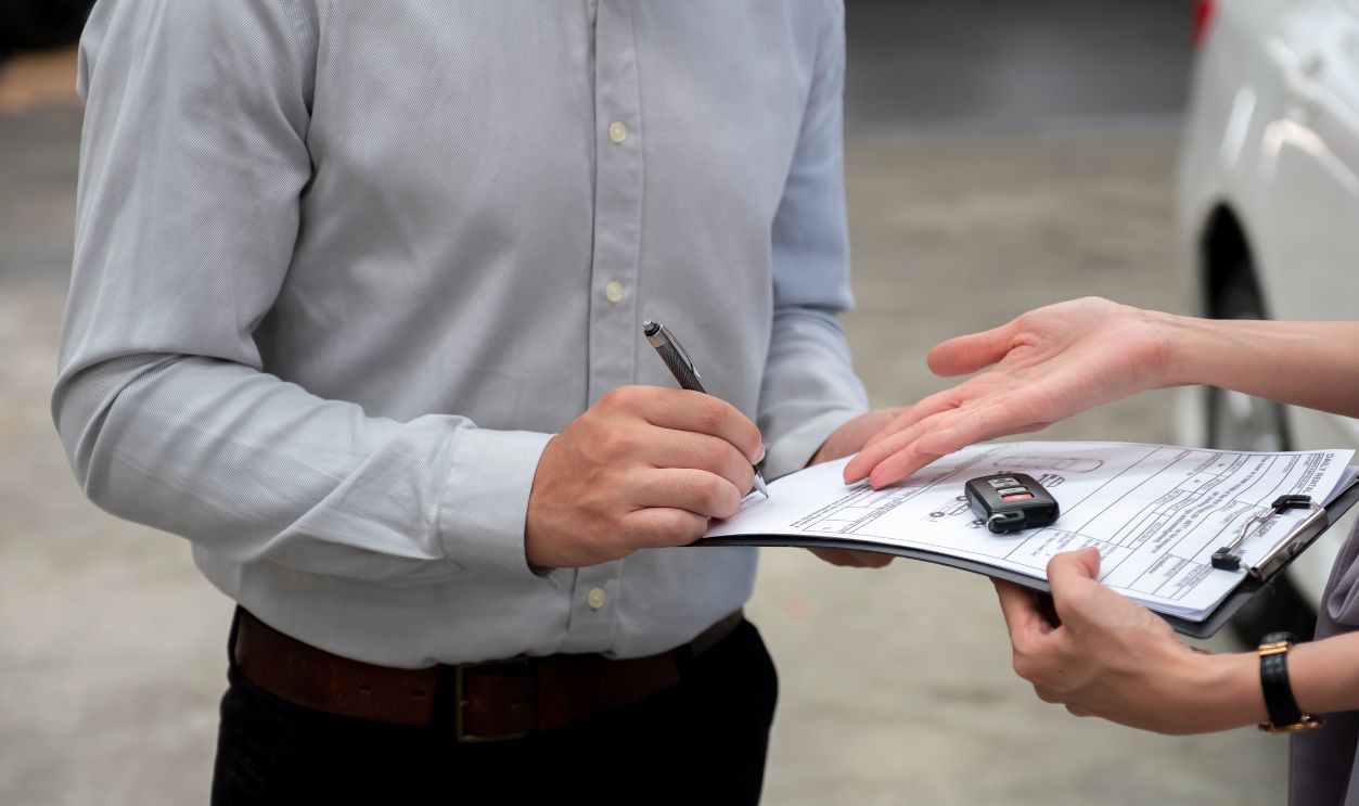 Car rental agency giving car rental contract to client for signing. Car rental business.
