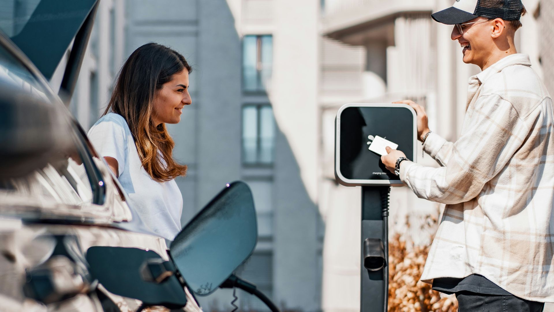 a man and a woman are charging their cars