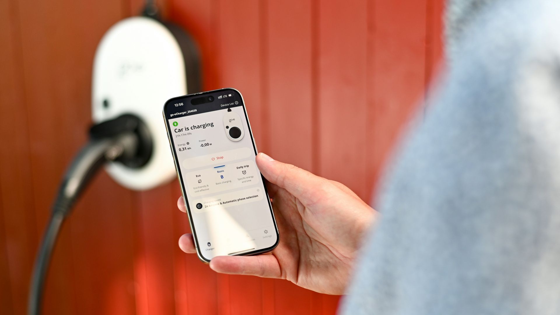 Person uses phone to control electric vehicle charger.