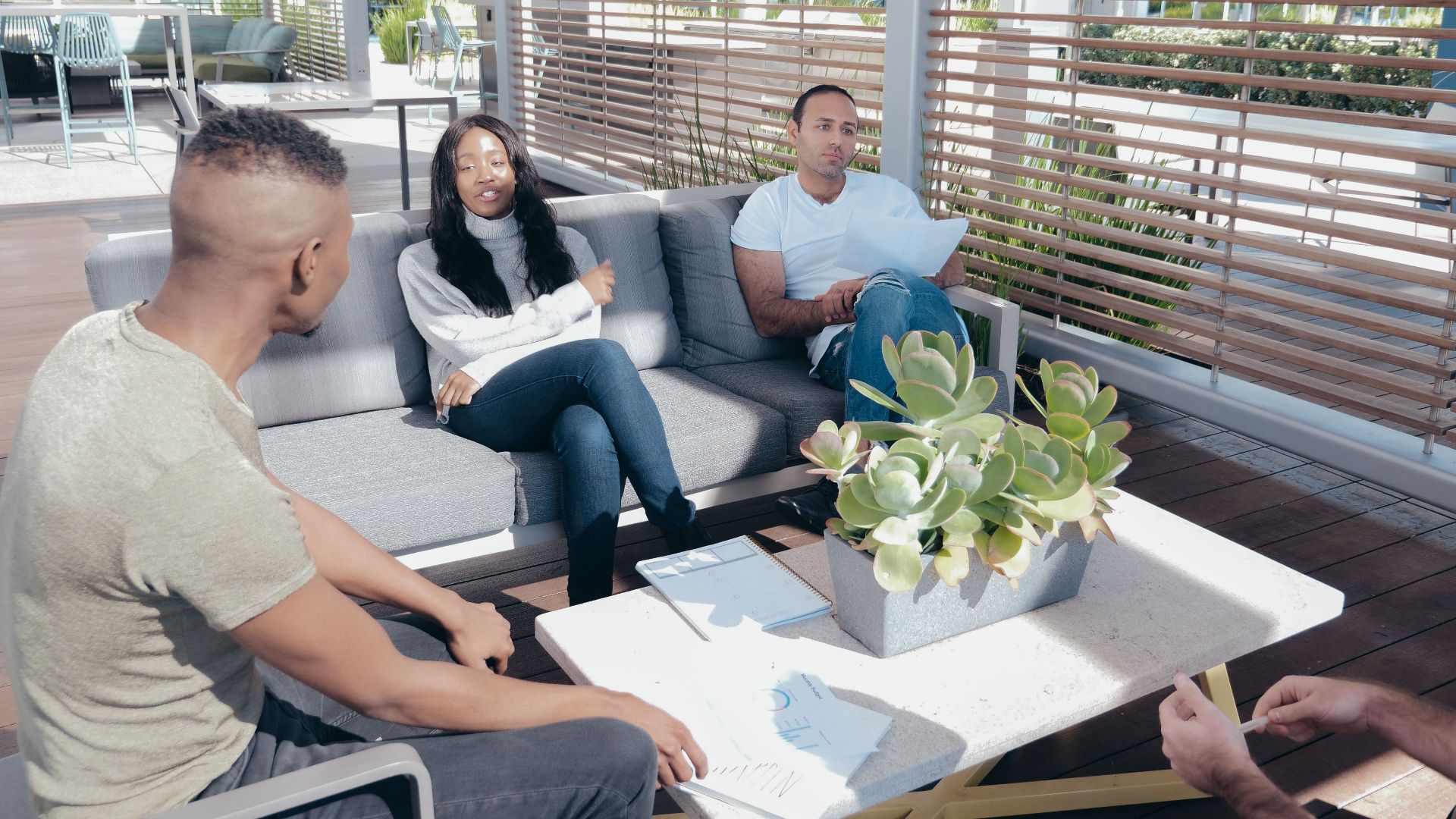 Diverse group of colleagues discussing strategies in a modern office lounge setting.