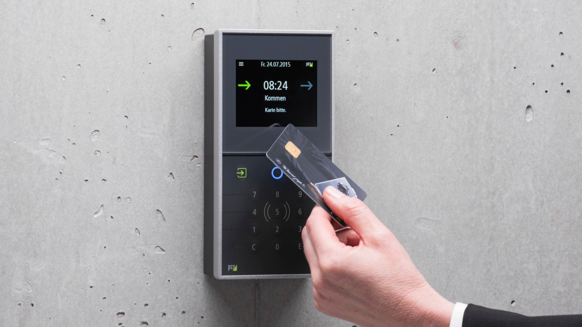 A businessman uses a secure card reader access system against a concrete wall.