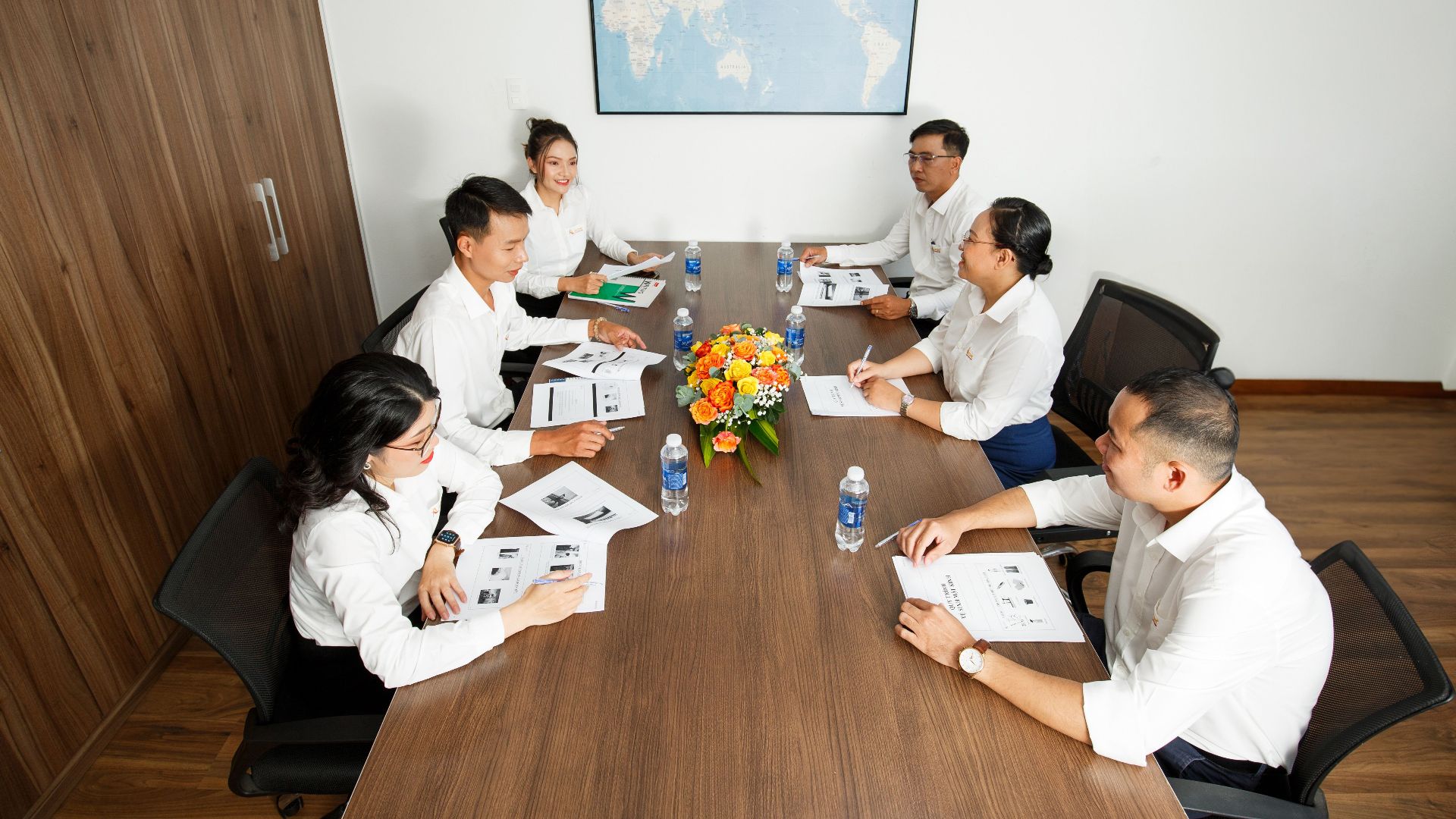 Group of professionals having a strategic business meeting at a conference table in a modern office setting.