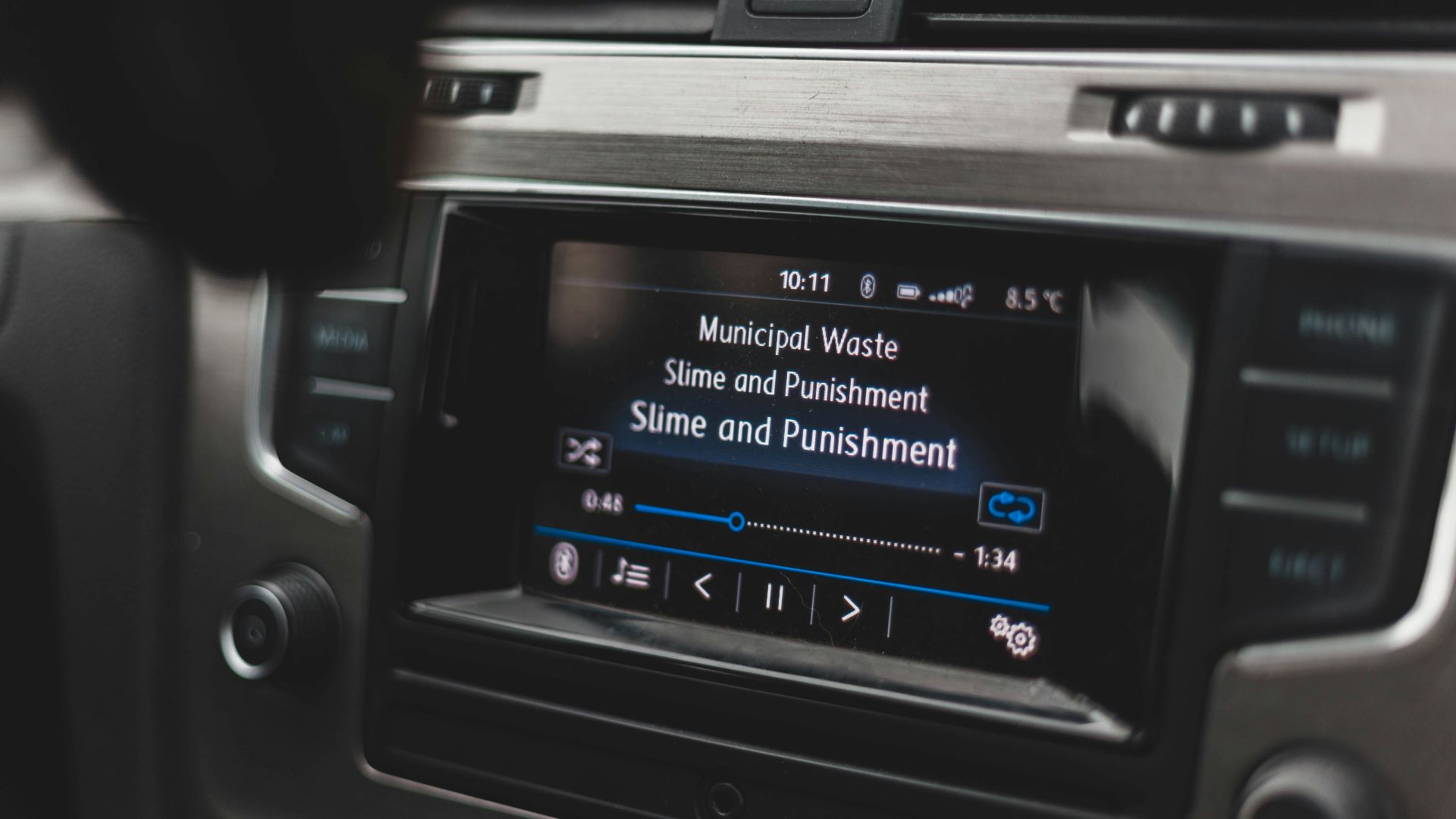 a car dashboard with a radio and a remote control