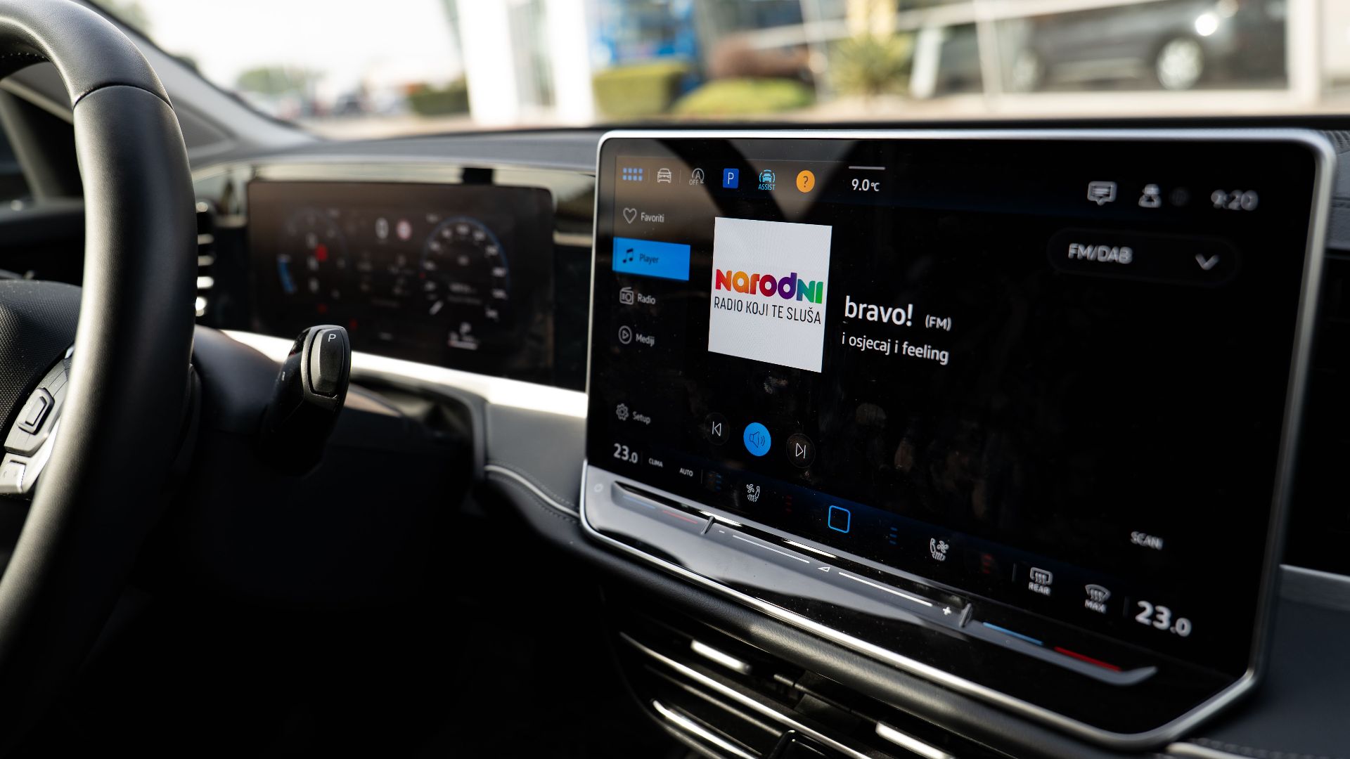 Inside view of a car with a sleek digital dashboard showing navigation and media controls.