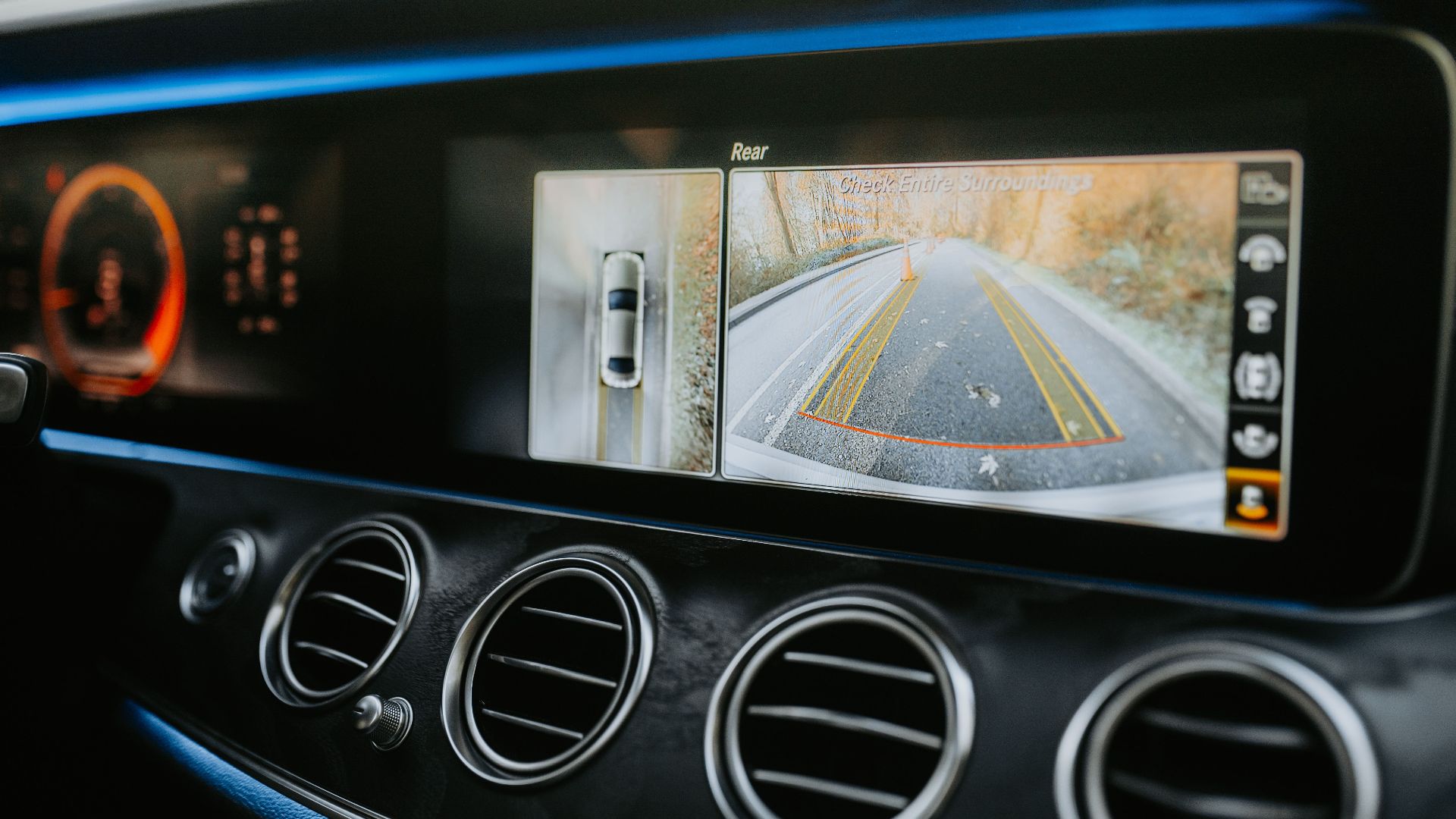 Close-up of a car dashboard showcasing a rear-view camera display and modern electronics.
