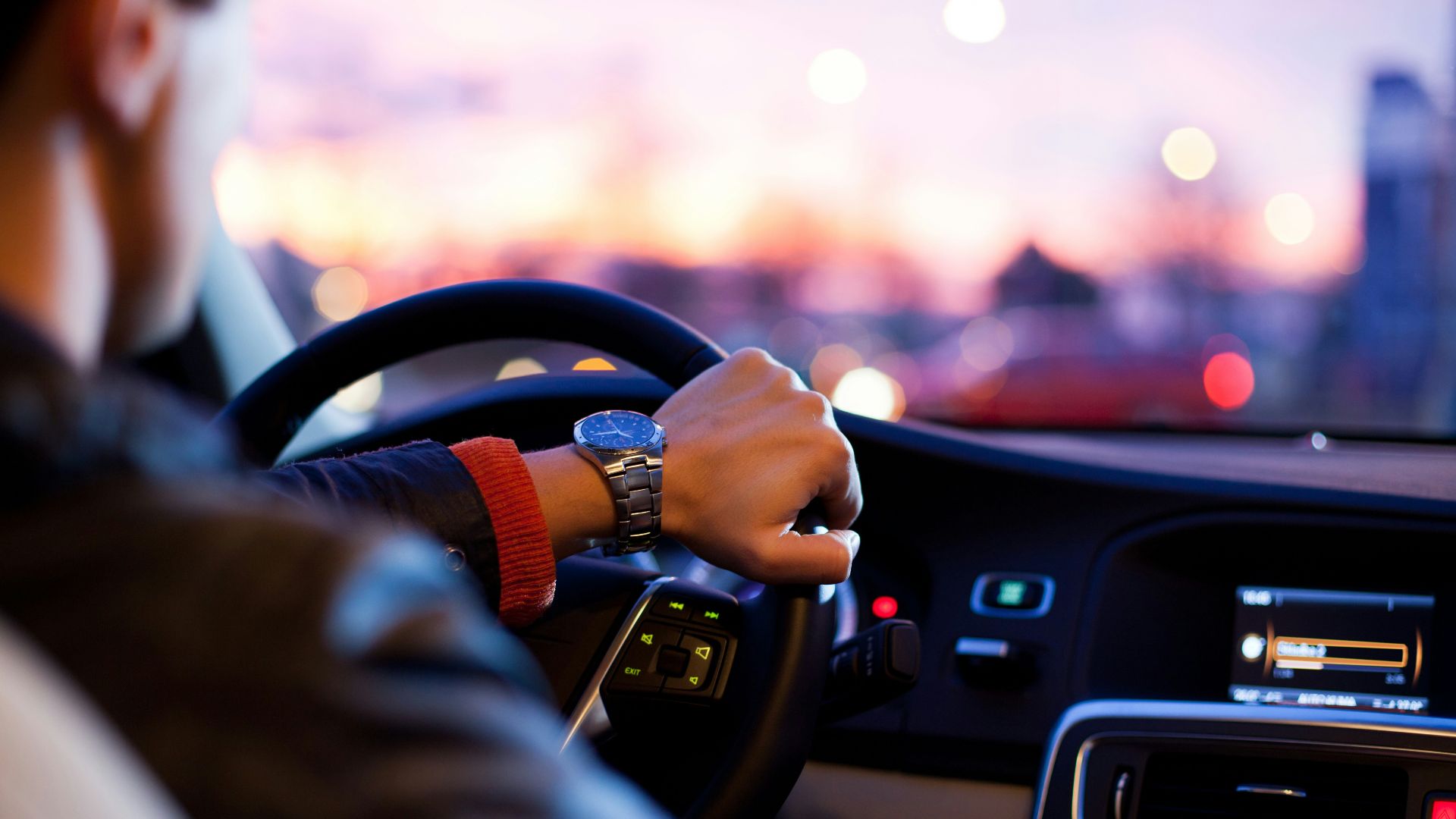 man driving a car wearing wrist watch