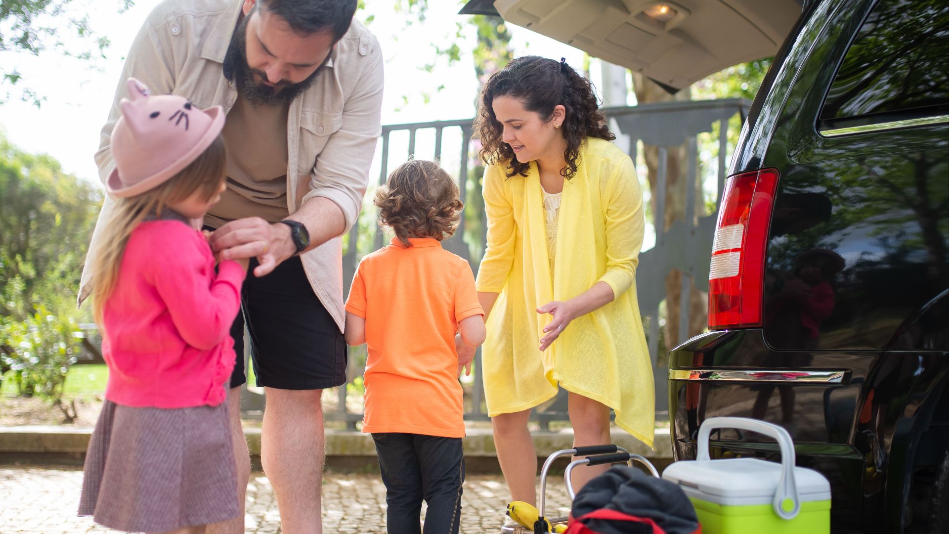 Cheerful family preparing car for a day trip in sunny Portugal.
