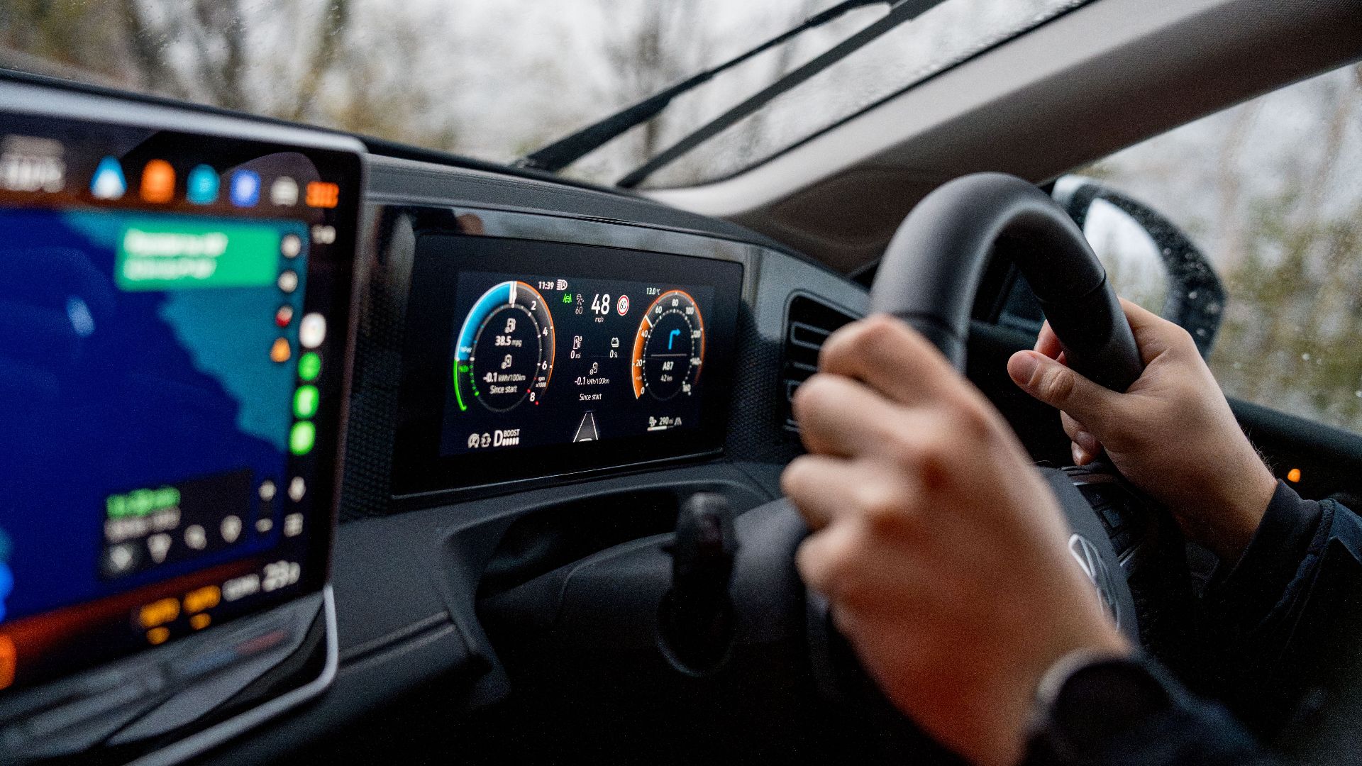 Person driving a car with modern dashboard and GPS navigation system.