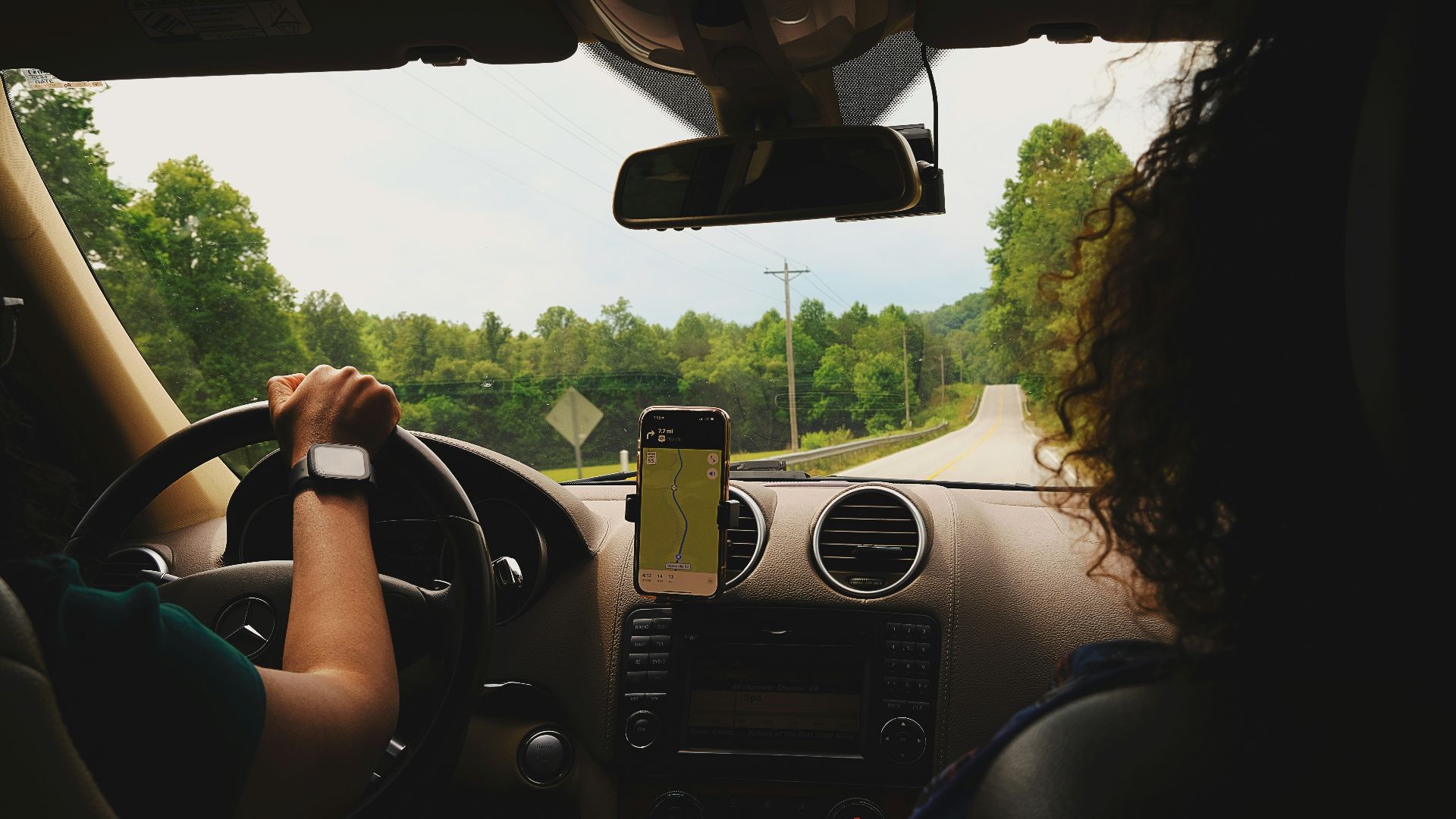 a woman driving a car while holding a cell phone